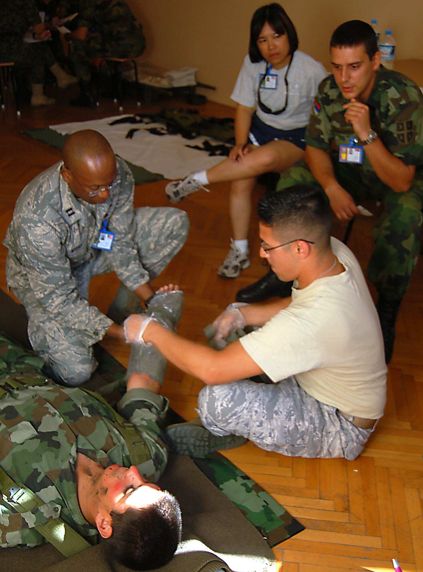 NIS, Serbia – Capt. Radcliffe Myers, 86th Medical Operations Squadron clinical nurse at Ramstein Air Base, Germany; and Staff Sgt. Brayan Jimenez, 86th Aerospace Medicine Squadron medic, also from Ramstein AB; practice applying dressing and bandages to a simulated burn victim played by Stefan Krstic, Serbian Armed Forces soldier, while Capt. Roslyn Thomas, Landstuhl Regional Medical Center nurse in Landstuhl, Germany, and Senior Sgt. Nenad Stevanovic, SAF medical support commander, discuss the process during a military medical training exercise in Central and Eastern Europe, or MEDCEUR 2009, trauma nursing training course taught by members of SAF medics Sept. 4. (U.S. Air Force photo/Senior Airman Kali L. Gradishar)