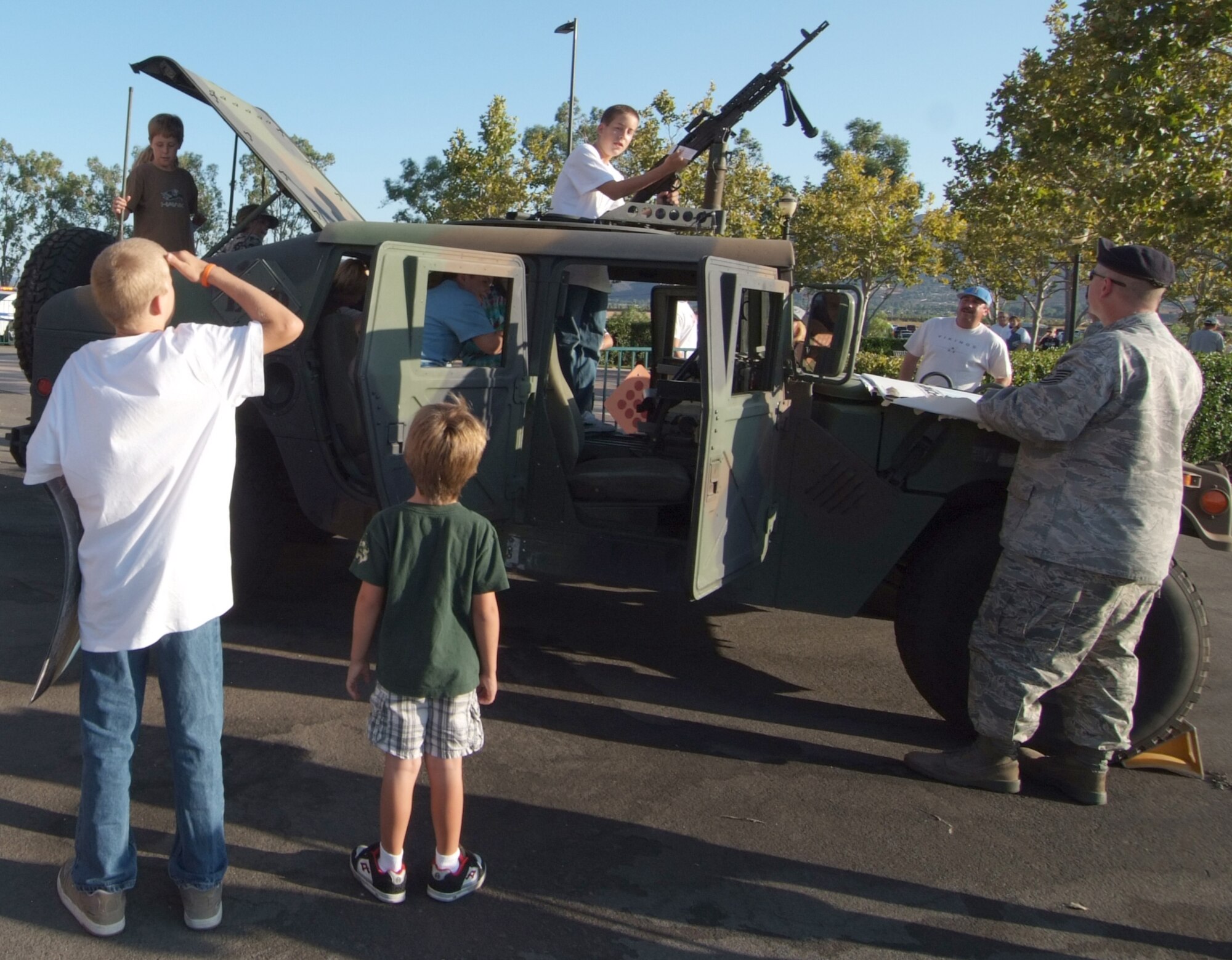 U.S. Air Force Tech. Sgt. Michael Murray, a security specialist with the 452nd Security Forces Squadron at March ARB, displays a military humvee to children on their way into the baseball game. (U.S. Air Force photos by Tech. Sgt. Joe Zuccaro)