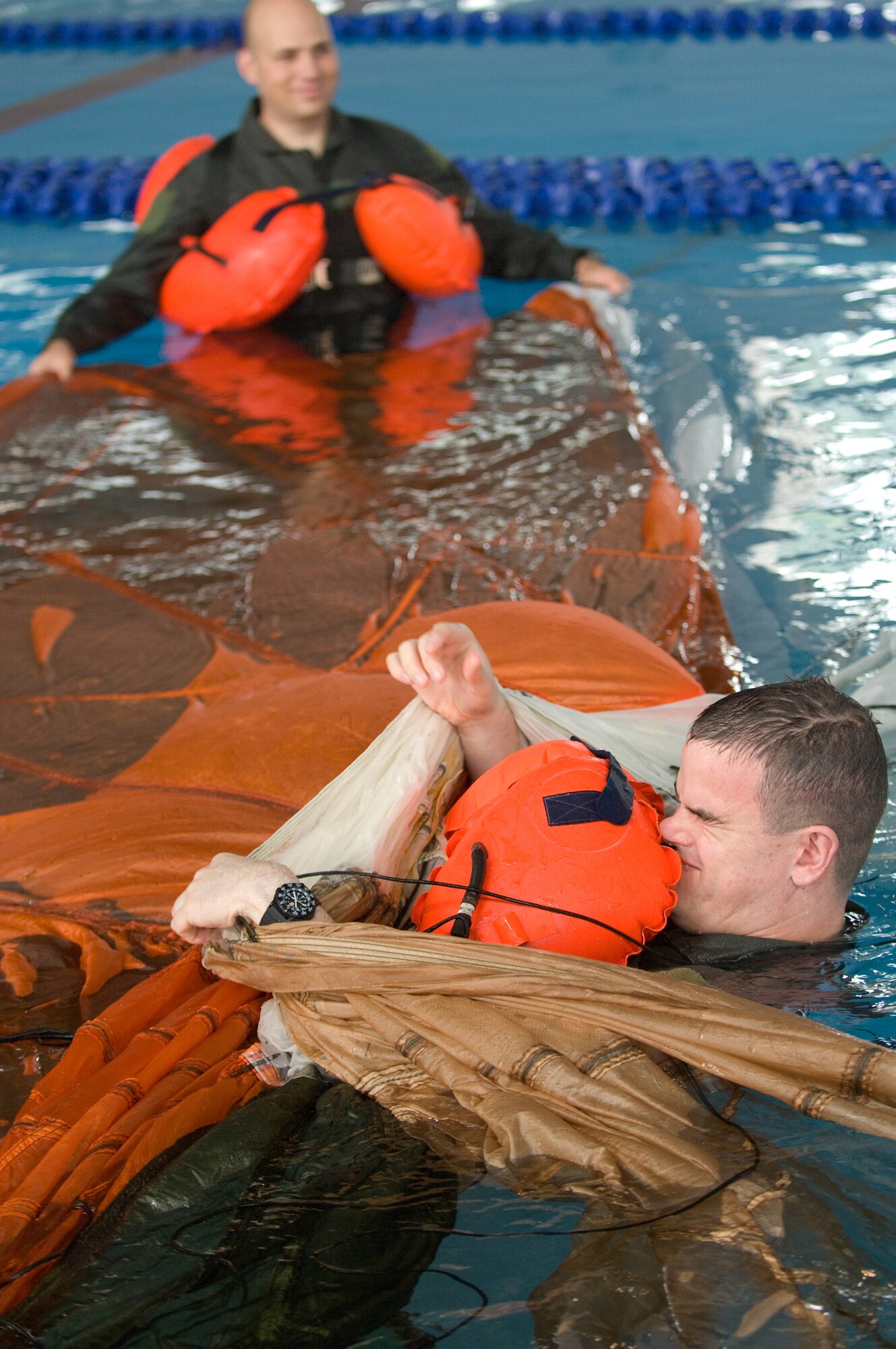 YOKOTA AIR BASE, Japan -- Maj. Wesley Kirk, 36th Airlift Squadron pilot, extricates himself from a parachute canopy during water survival refresher training recently at the Natatorium Indoor Pool. Survival, evasion, resistance and escape technicians teach the course to aircrew members at least once every three years. The training is especially important for Yokota aircrews, who routinely fly long distances over large bodies of water in the Pacific Rim. (U.S. Air Force photo/Osakabe Yasuo) 

