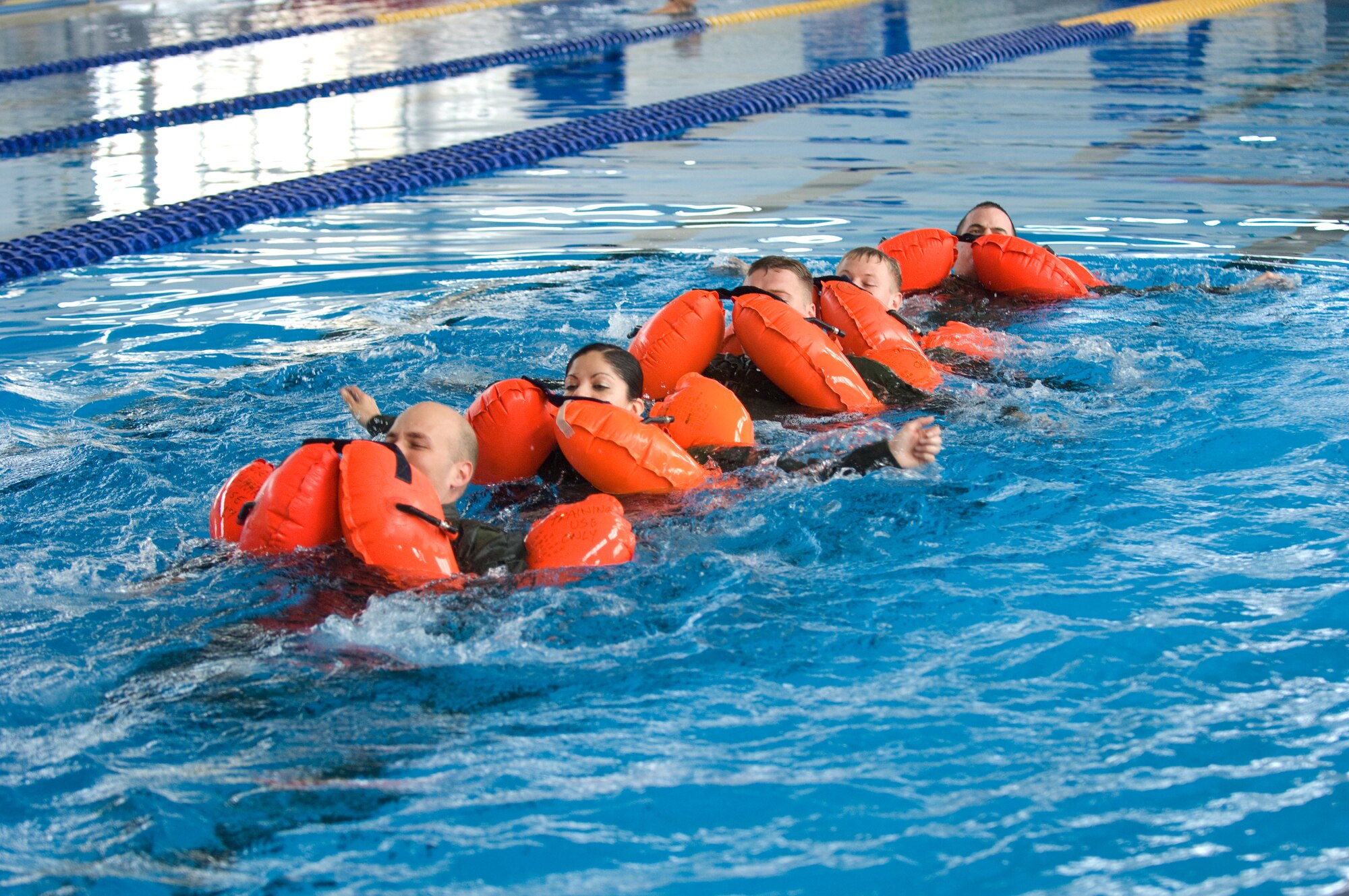 YOKOTA AIR BASE, Japan -- Aircrew members practice group swimming during water survival refresher training recently at the Natatorium Indoor Pool. Survival, evasion, resistance and escape technicians teach the course to aircrew members at least once every three years. The training is especially important for Yokota aircrews, who routinely fly long distances over large bodies of water in the Pacific Rim. (U.S. Air Force photo/Osakabe Yasuo) 



