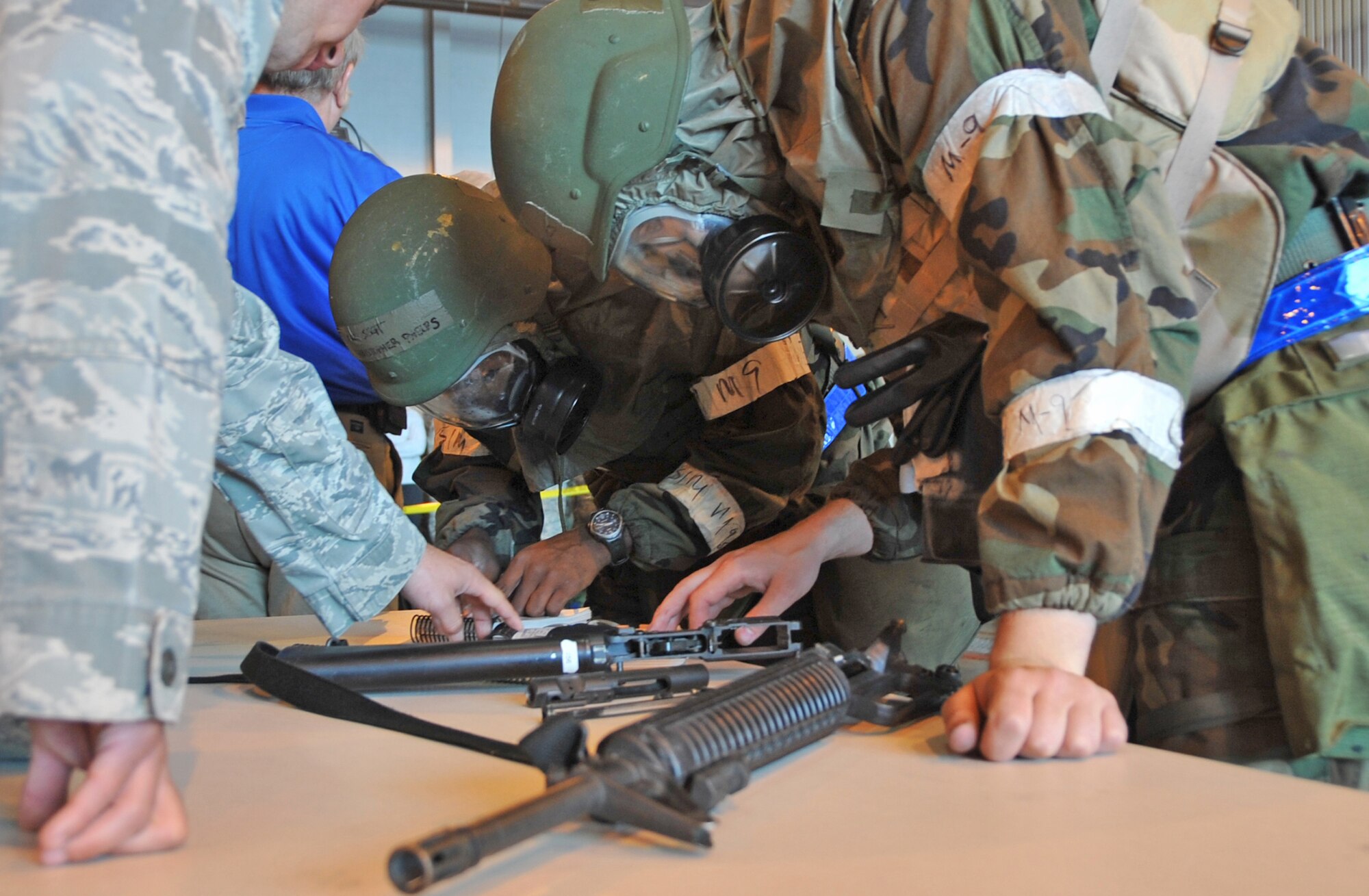 OFFUTT AIR FORCE BASE, Neb. - Team members from the 55th Communications Group disassemble an M-16 at the Bennie Davis Maintenance Facility, Sept. 3, 2009. Airmen gathered for a commander's call followed by a series of competitive events to prepare for the Operation Readiness Inspection Sept. 10 - 16. U.S. Air Force photo by Jeff W. Gates.