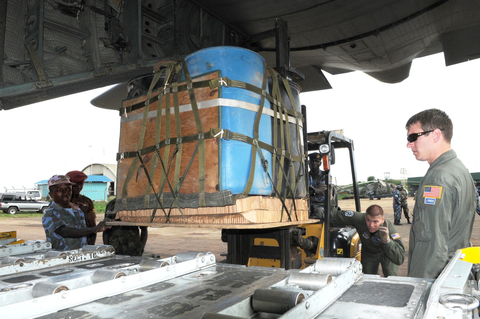 Staff Sgt. Brock Knobloch directs the forklift operator as U.S. and Ugandan troops position an airdrop pallet on a C-130 during a theater security cooperation event Hercules Aug. 28, 2009, at Entebbe Air Base, Uganda. (U.S. Air Force photo/Maj. Paula Kurtz) 