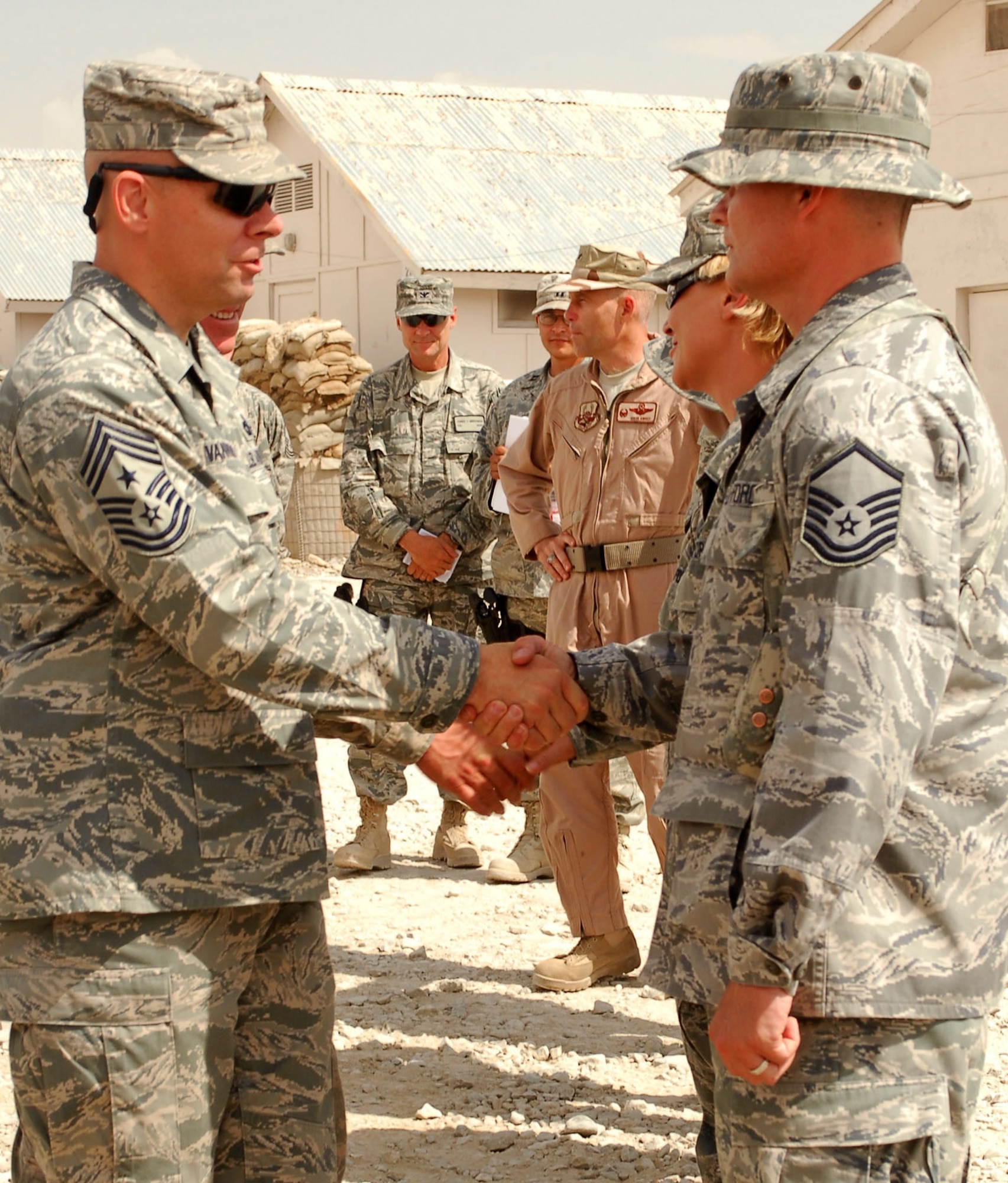 Chief Master Sgt. Dennis Vannorsdall congratulates Master Sgt. Gary Walters, Medical Embedded Training Team, for being an forward operating base superior performer Aug. 30, 2009. The Airmen are assigned to FOB Lightning as joint expeditionary tasked Airmen who work day-to-day for  Army commanders while they're also administratively assigned to Air Force commanders under the 755th Air Expeditionary Group at Bagram Airfield, Afghanistan. The JET Airmen are part of the Embedded Training Team, which mentors Afghan National Army Forces in many skills to include medical and public affairs. Chief Vannorsdall is the 455th Air Expeditionary Wing command chief. (U.S. Air Force photo/Capt. David Faggard) 
