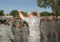 Airman Andrew Vanderwal pumps up Airmen waiting to enter Lackland's Gateway Chapel for Contemporary Service Aug. 16. Airman Vanderwal is a volunteer with the white rope program. (U.S. Air Force photo/Alan Boedeker)                                