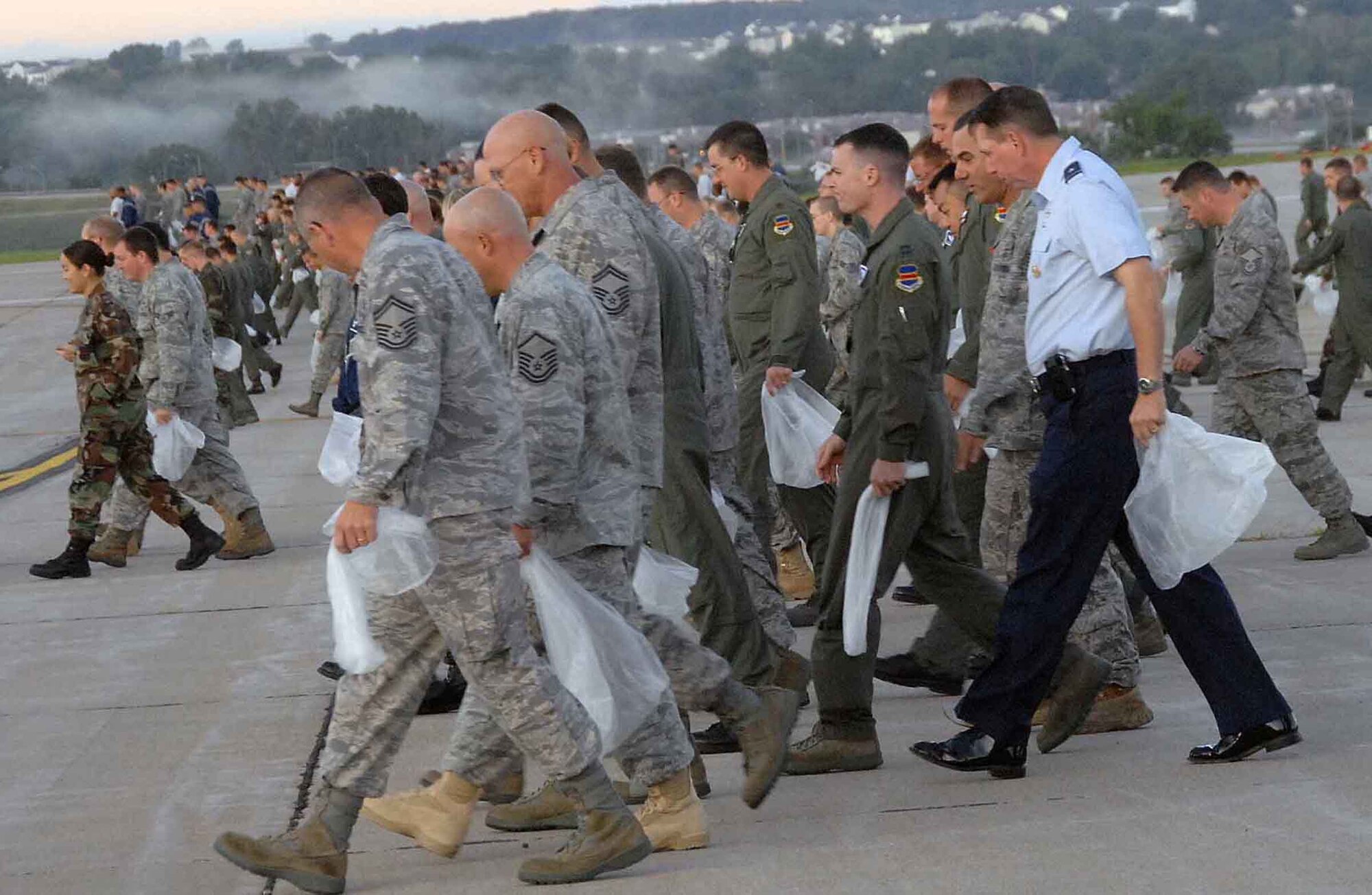 OFFUTT AIR FORCE BASE, Neb. - Various Offutt Airmen including Brig. Gen. John N.T. Shanahan, 55th Wing commander, look for litter during a foreign object debris detection walk Aug. 31 on the Offutt flightline. The FOD walk took place after the 2009 "Defenders of Freedom" Open House and Air Show to ensure the safety of planes using the runway. U.S. Air Force photo by Kendra Williams.