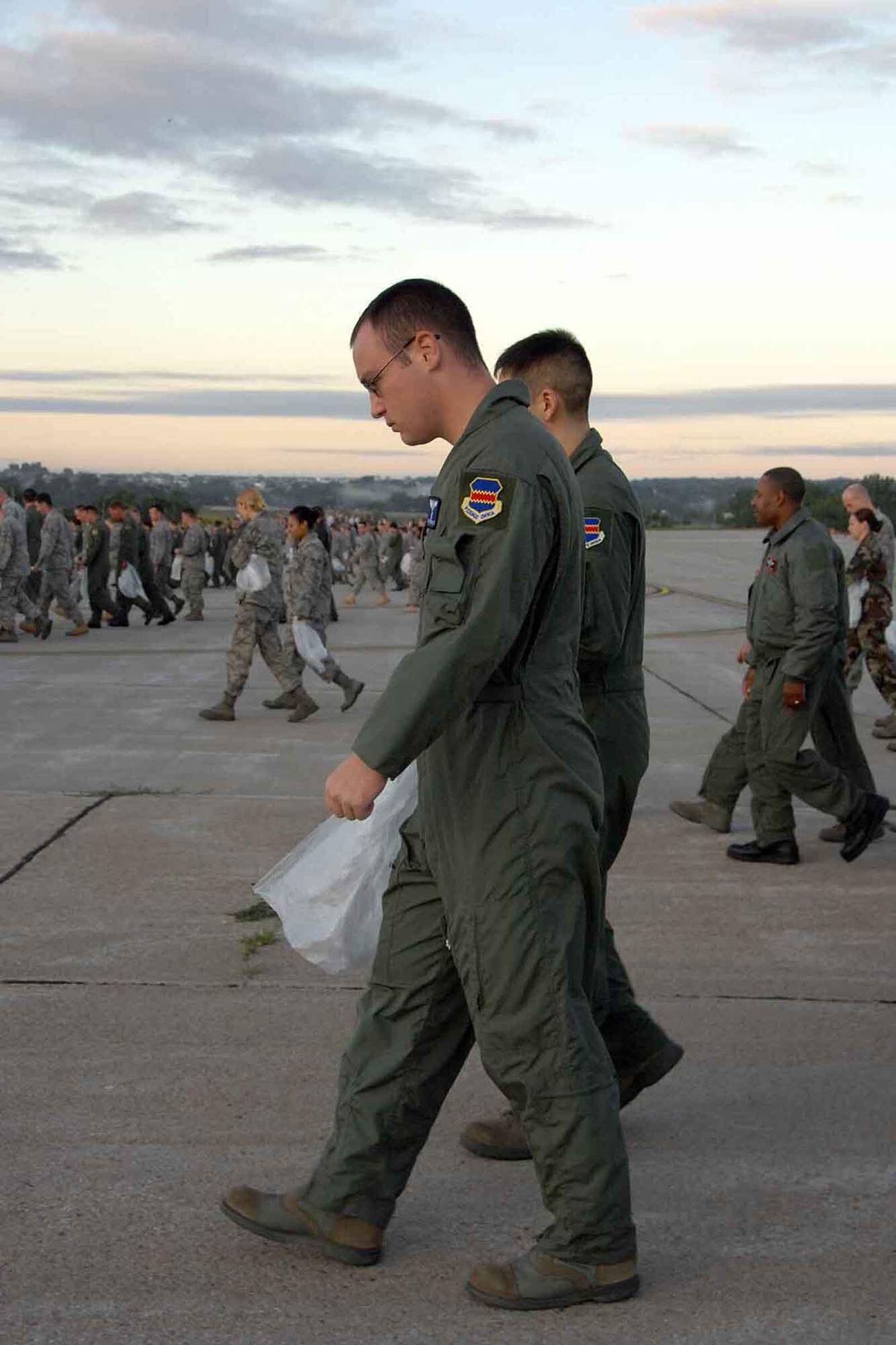 OFFUTT AIR FORCE BASE, Neb. - Senior Airman Ethan Derrick, a linguist with the 97th Intelligence Squadron, and other Offutt Airmen look for litter during a foreign object debris detection walk Aug. 31 on the Offutt flight line. The FOD walk took place after the 2009 "Defenders of Freedom" Open House and Air Show to ensure the safety of planes using the runway. U.S. Air Force photo by Kendra Williams.