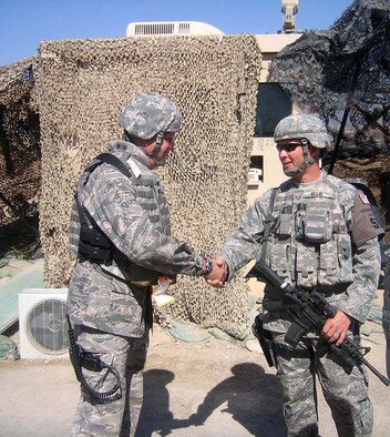 Maj. Jere High, (left) 446th Civil Engineer Squadron, McChord Air Force Base, Wash., greets Staff Sgt. Eric Ellis, 446th Security Forces Squadron, McChord AFB, at Kirkuk Regional Air Base, Iraq. Both Air Force Reserve Airmen are deployed to Iraq. Major High and about 40 other Reserve Airmen from the 446th CES deployed at the end of August, while Sergeant Ellis is one of about 20 446th SFS Airmen who have been in Iraq since July. (Courtesy photo)