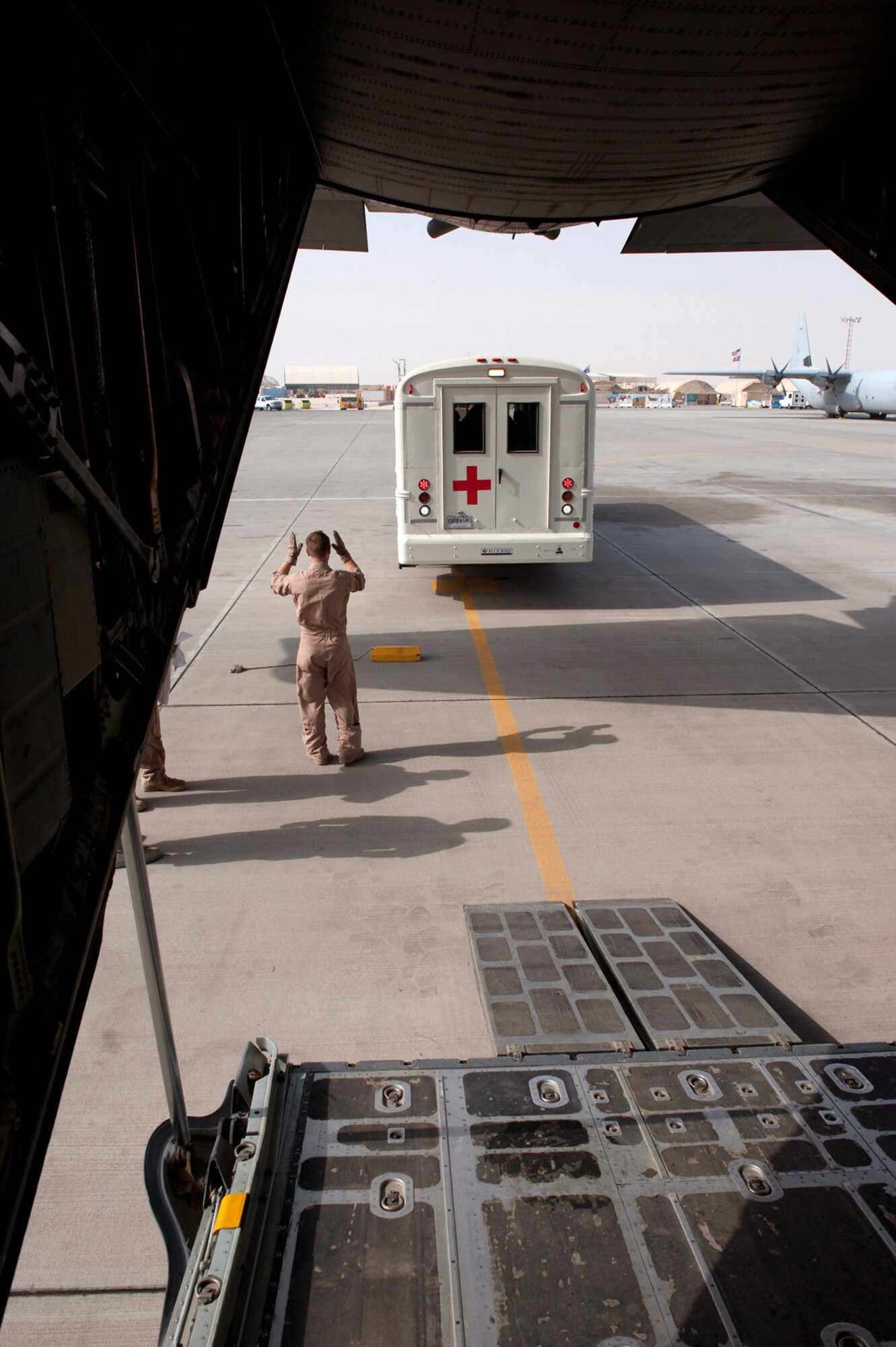 Tech. Sgt. Cory Preusse positions a medical transportation bus behind a C-130 Hercules Aug. 15, 2009, at an air base in Southwest Asia. Sergeant Preusse is a 746th Expeditionary Airlift Squadron loadmaster deployed from the Minnesota Air National Guard. (U.S. Air Force photo/Staff Sgt. Robert Barney) 