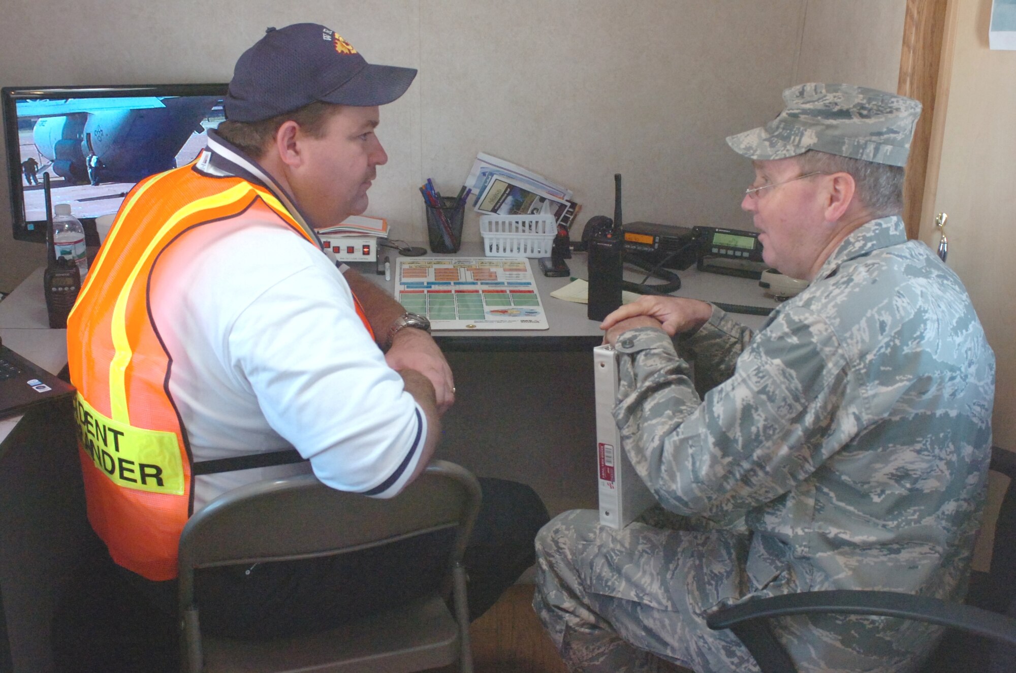 Lt. Col. Stanley Evans, commander of the 61st Civil Support Team, (right) discusses entry procedures and containment options for a hazardous chemical  with Walnut Ridge Fire Chief Alan Haskins, incident commander during an exercise at the Walnut Ridge Airport on Tuesday, September 1, 2009.  The exercise involved a scenario where a C-130 from the Arkansas Air National Guard was carrying a hazardous chemical which overturned during a hard landing at the airport.  The spill resulted in a compartment fire aboard the aircraft and the vapors from the chemical overcame the crew.  The aircraft and crew supporting the exercise for the local HAZMAT response drill came from the 189th Airlift Wing of the Arkansas Air National Guard located at Little Rock Air Force Base. (Photo by Maj. Keith Moore, public affairs officer for the Arkansas Air National Guard.) 