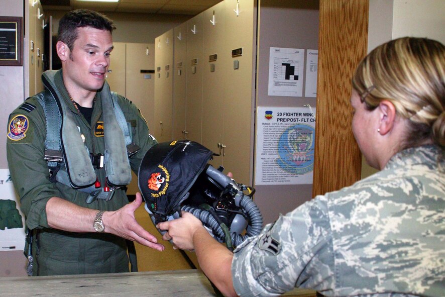 SHAW AIR FORCE BASE, S.C. -- Flight Lt. Andrew Mallery-Blythe, 79th Fighter Squadron F-16 pilot, takes his helmet from an aircrew life support specialist here Aug. 21. Leftenant Mallery-Blythe is an exchange pilot from the British Royal Air Force. The pilot exchange program trades fliers from different countries to learn how allies fly, train and fight. The purpose of the program is to improve international relations and pilot adaptability. ( (U.S. Air Force photo/Staff Sgt. John Gordinier)