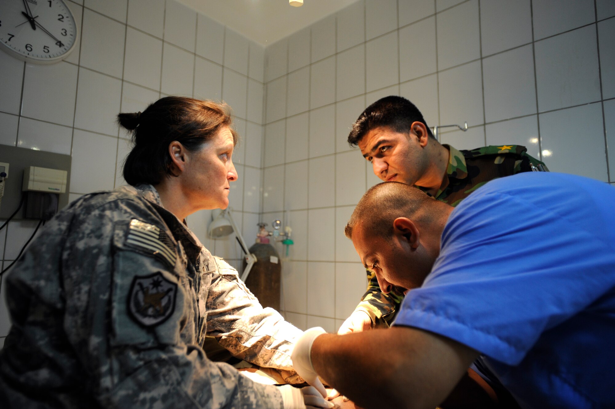 Army Staff Sgt. Barbara Seabert speaks to her Iraqi counterparts while examining a patient Aug. 17, 2009, at Camp Ur, Iraq. The Iraqi camp boasts a fully functioning medical clinic complete with a three-bay emergency room, pharmacy, dentist, radiology department and public health, as well as a highly trained team of doctors, nurses and technicians on staff. Sergeant Seabert is a Tallil Logistics Military Advisory Team medical adviser. (U.S. Air Force photo/Staff Sgt. Shawn Weismiller) 