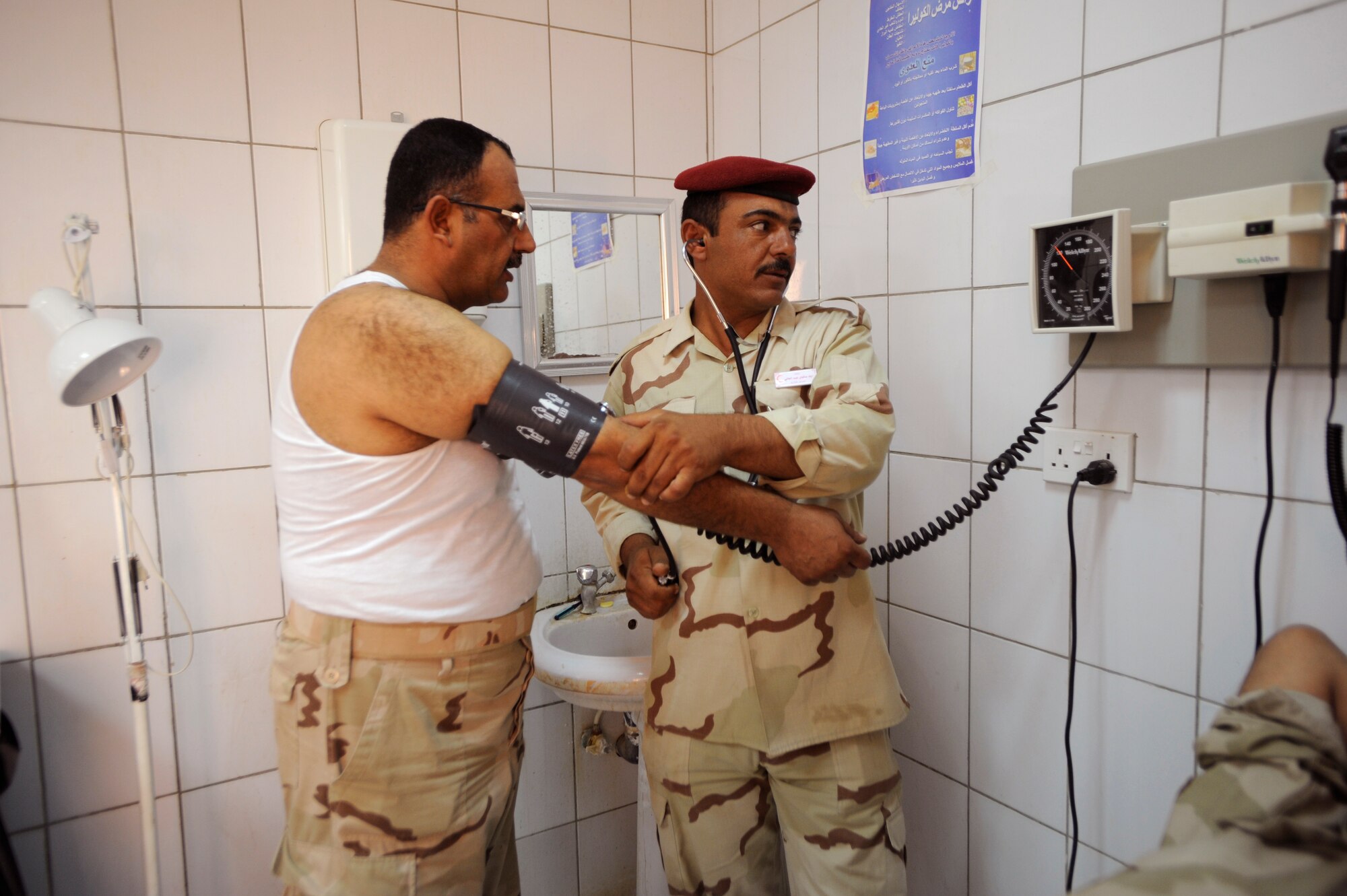 An Iraqi medical technician exams a fellow soldier in the clinic Aug. 17, 2009, at Camp Ur, Iraq. The Iraqi camp boasts a fully functioning medical clinic complete with a three-bay emergency room, pharmacy, dentist, radiology department and public health, as well as a highly trained team of doctors, nurses and technicians on staff. (U.S. Air Force photo/Staff Sgt. Shawn Weismiller) 