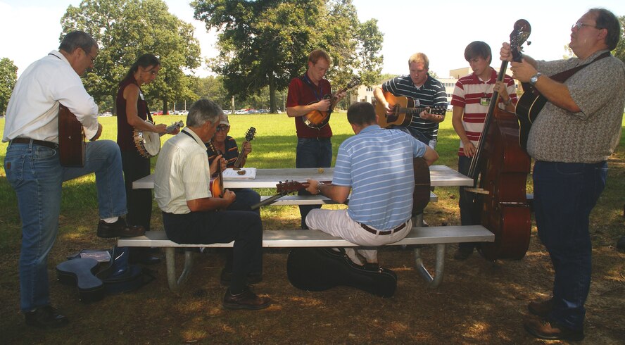 From left, Joe Popp, Maureen Burke, David Browning , Sam Finney, Andy Escue, Chris Davis, Michael Lynch, David Yoder and Kraig Smith gather in the area between the A&E and the Carroll buildings every Tuesday to play music during the lunch break. Rylan Cox, not pictured, is the third original founder of the jam session group. (Photo by Philip Lorenz III)
