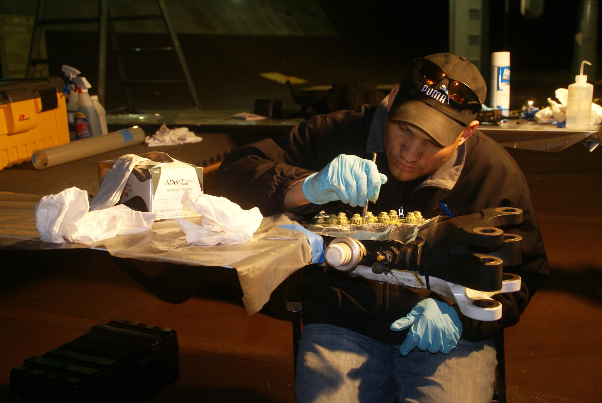 Rosario-Ferrer performs a periodic inspection of the UH-60 blade cuffs after a test. He said there is a need to strip the paint and sealing compounds with a non metallic scraper using a magnifying glass and some light to inspect for any cracks, corrosion, nicks and scratches that are visible between the blade attachments bolts and the cuff itself. (Photo by Philip Lorenz III)