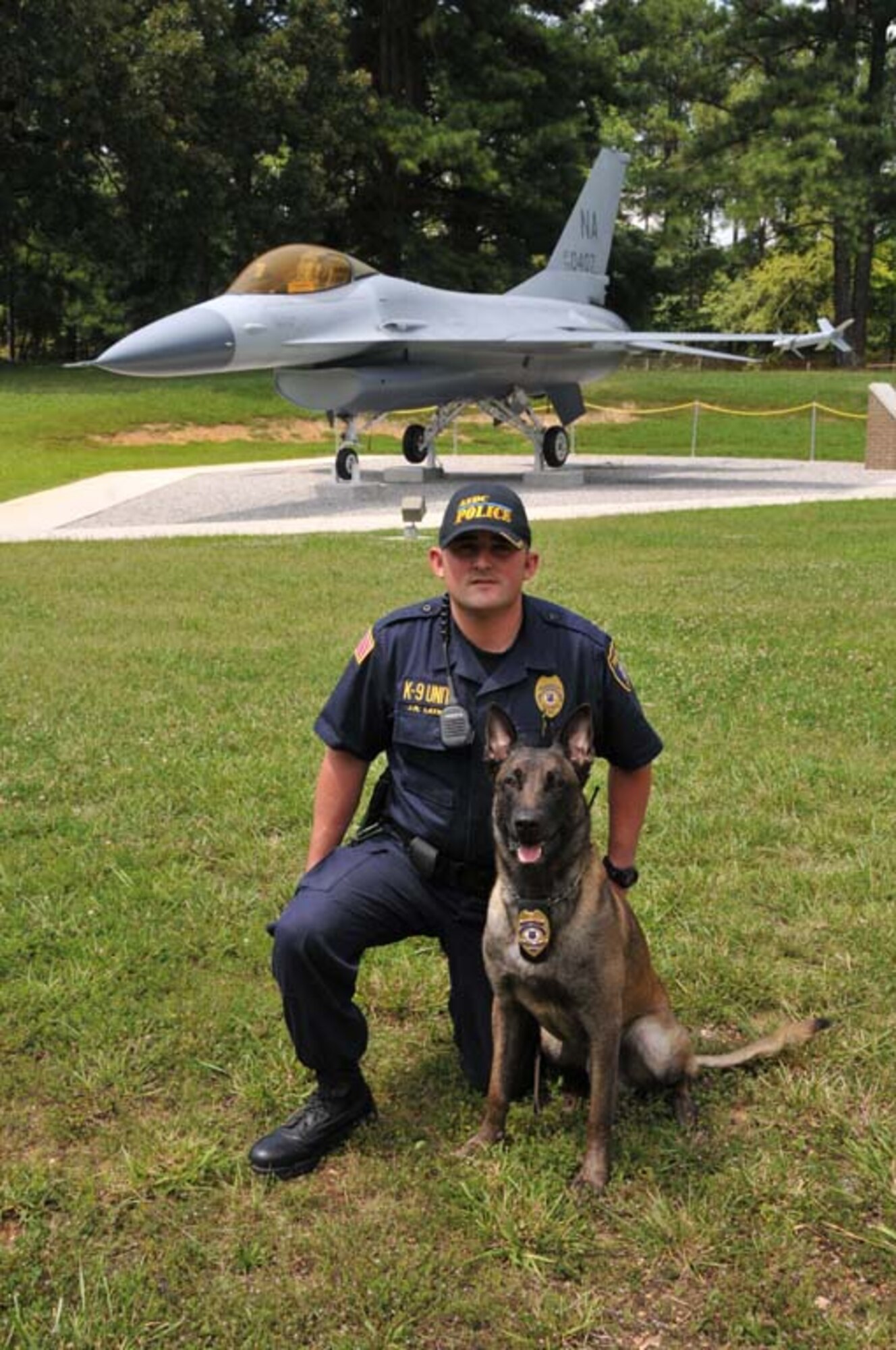 Jason Layne, handler and Arnold Engineering Development Center Detection Unit, K-9, officer, kneels with Bikkel, the new security dog. (Photo by David Housch)