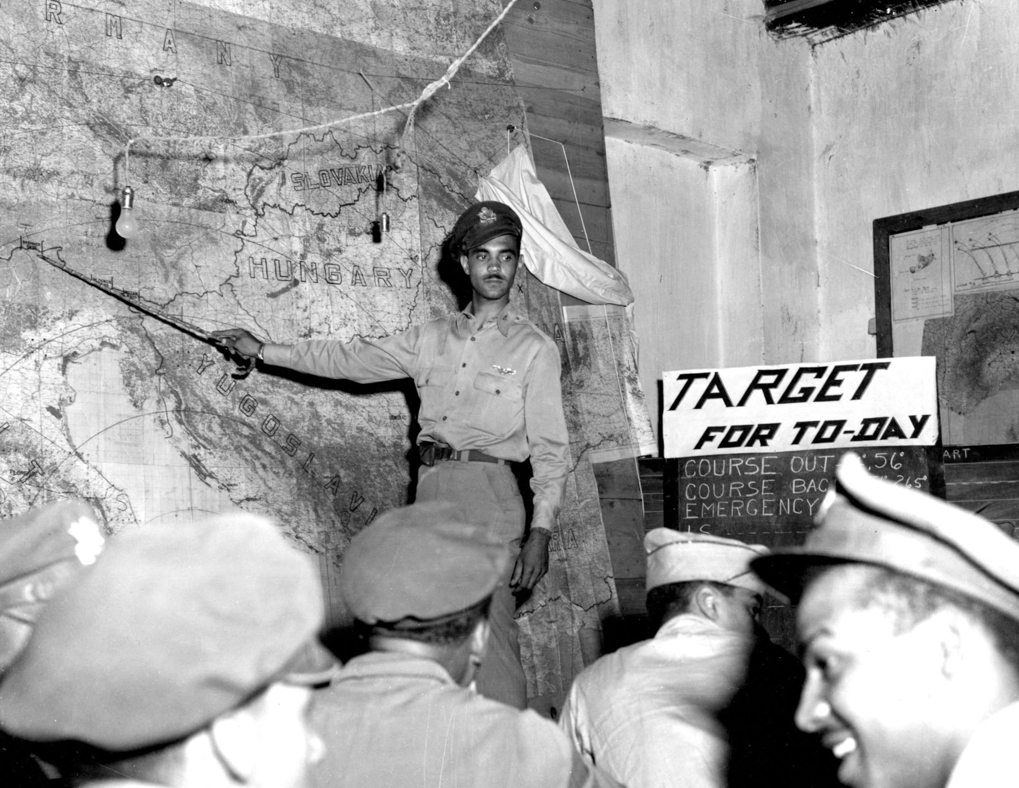 The 332nd Fighter Group is briefed on what to expect as they head north from Italy. The briefer is Lt. (later Col.) Edward Gleed. (U.S. Air Force photo)