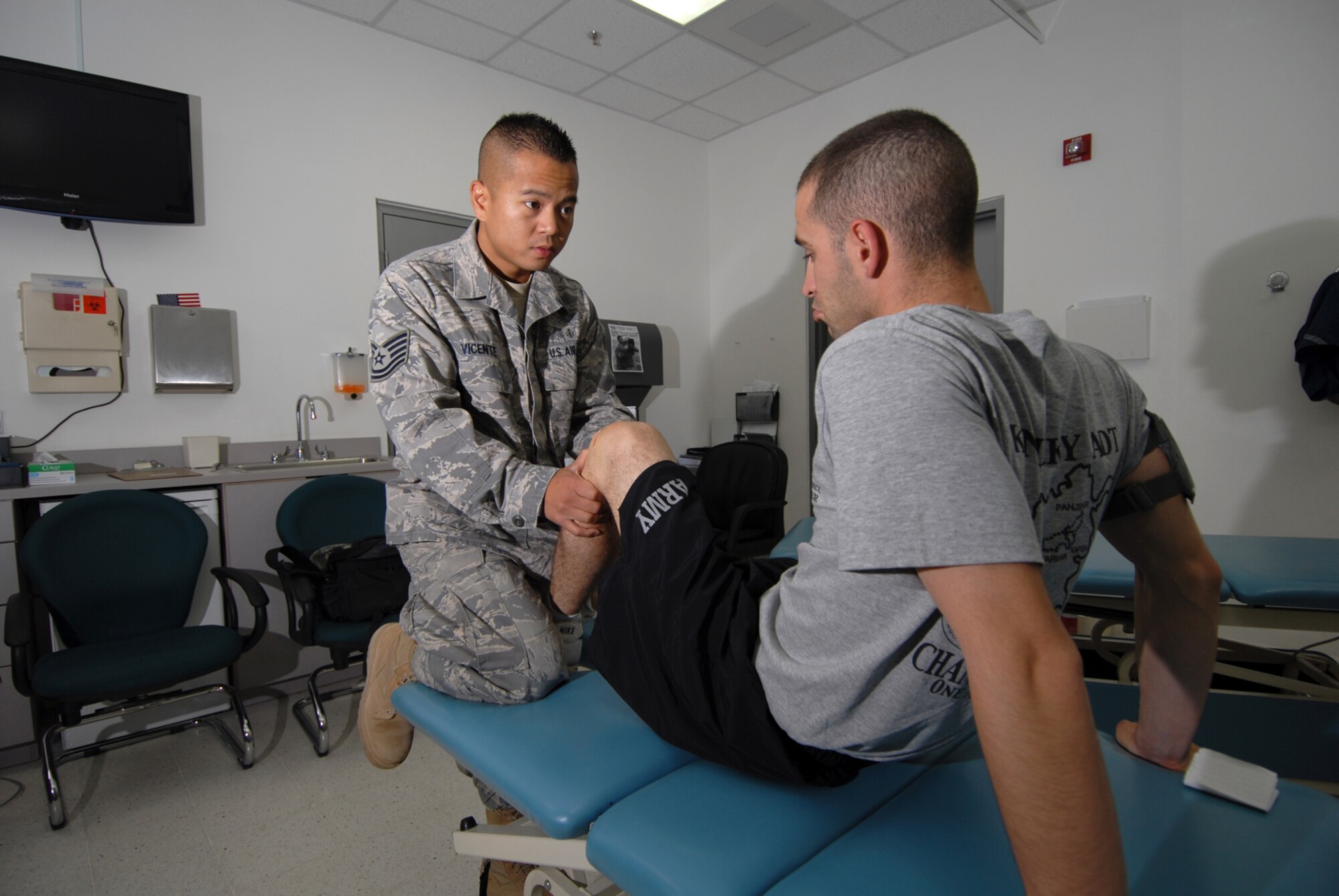 Staff Sgt. Martin Vicente, 379th Expeditionary Medical Group physical therapy craftsman, assists Army Staff Sgt. Nicholas Tomasi, a post-op knee patient, with improving mobility through the use of advanced treatment techniques, such as joint mobilization, Sept. 8. Sergeant Vicente is deployed from Hickam Air Force Base, Hawaii in support of Operations Iraqi and Enduring Freedom.  (U.S. Air Force Photo/Tech. Sgt. Jason W. Edwards)