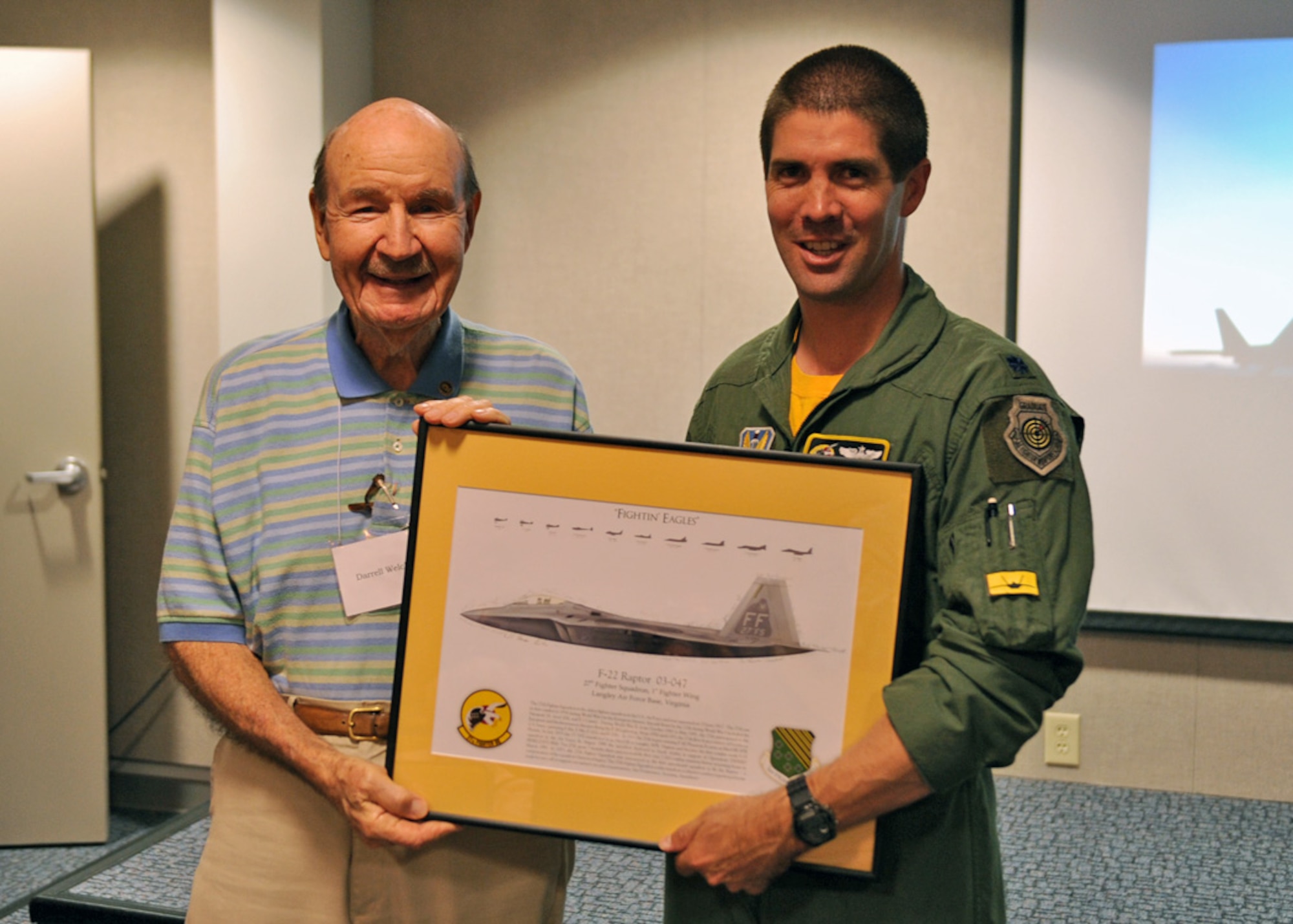 LANGLEY AIR FORCE BASE, Va. -- Darryl Welch, World War II Ace, accepts a picture of the F-22AA Raptor from Lt. Col. Lance Pilch, 27th Fighter Squadron commander, during the 1st Fighter Wing Reunion Tour here Sept.3. The tour updated veterans on how the Air Force is changing and where it will be in the future. Veterans had a chance to visit their old squadrons and meet the new Airmen working there. (U.S. Air Force photo/Airman1st Class Jonathan Koob)