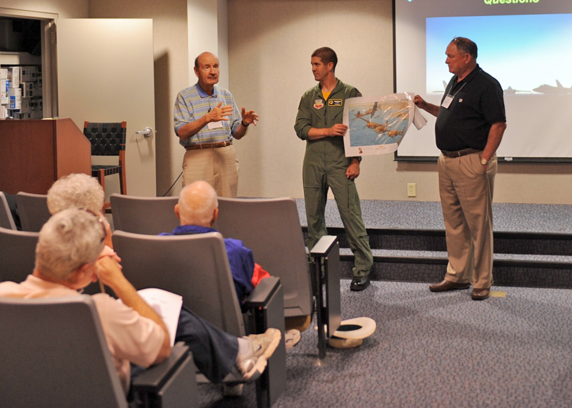 LANGLEY AIR FORCE BASE, Va. -- Darryl Welch, World War II Ace, presents a photo depicting one of his battle scenes to Lt. Col. Lance Pilch, 27th Fighter Squadron commander, during the 1st Fighter Wing Reunion Tour here Sept. 3. The tour updated veterans on how the Air Force is changing and where it will be in the future. Veterans had a chance to visit their old squadrons and meet the new Airmen working there. (U.S. Air Force photo/Airman1st Class Jonathan Koob)