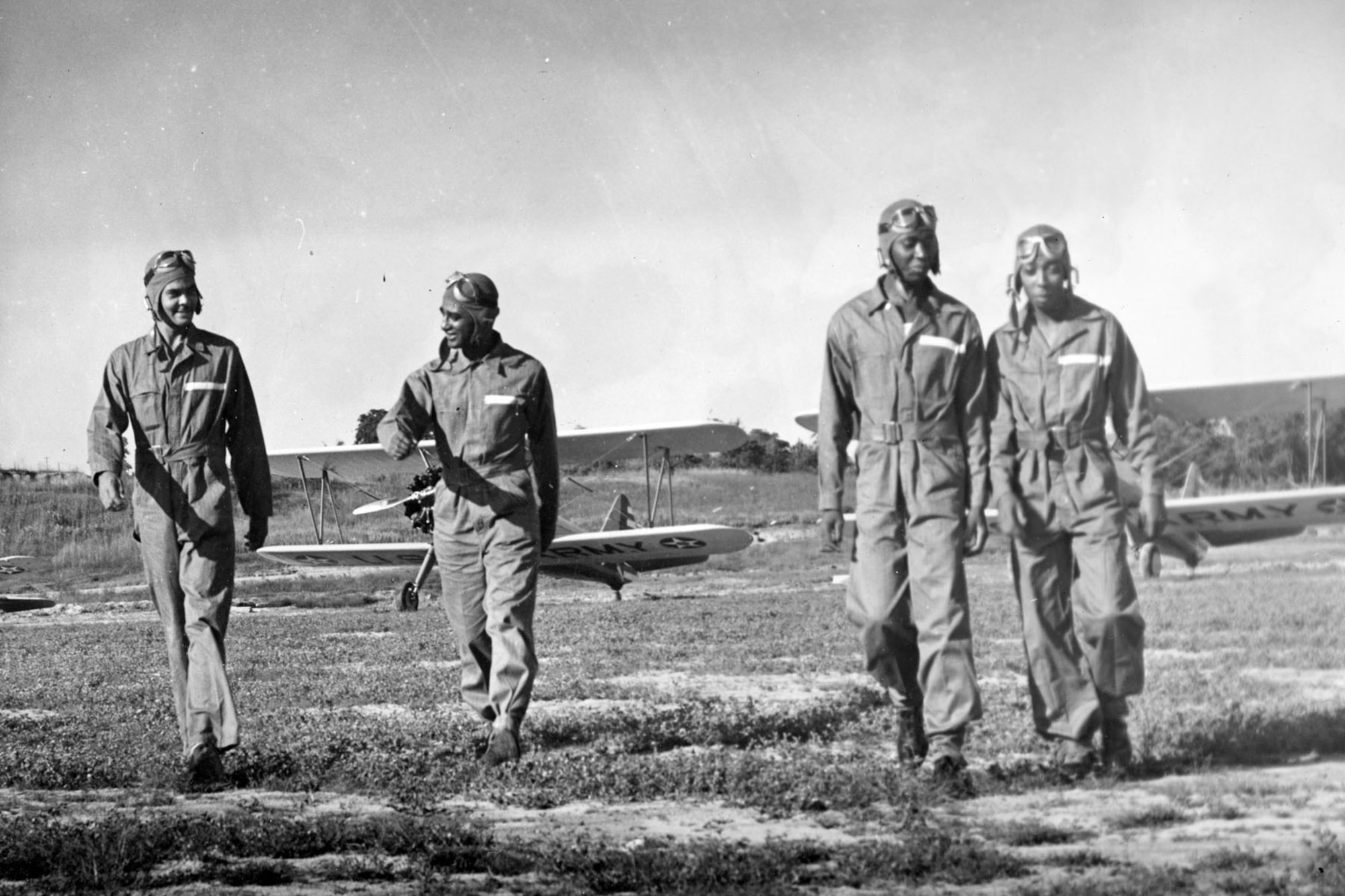 Tuskegee students talk about flying their Stearman biplanes. At far left is Capt. Benjamin O. Davis Jr., the squadron commander. (U.S. Air Force photo)