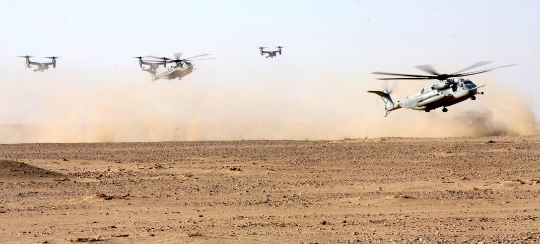 CH-53E Supper Stallion helicopters and MV-22B Ospreys land in the Kuwaiti desert during a helicopter assault training course near Camp Buehring, Kuwait, Sept. 3, 2009. The air crews are assigned to Marine Medium Tiltrotor Squadron 263, 22nd Marine Expeditionary Unit.