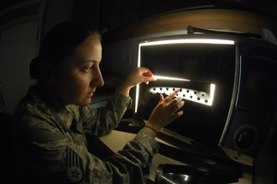 U.S. Air Force Staff Sgt. Nadine Muro, the nondestructive inspection noncommissioned officer-in-charge, 5th Maintenance Squadron, examines an X-ray film strip of B-52 Stratofortress aircraft parts to track their internal cracks and discontinuities at Minot Air Force Base, N.D., on Aug. 31, 2009.  Muro examines aerospace weapon system components and support equipment for structural integrity using nondestructive inspection methods and fluid analysis.  