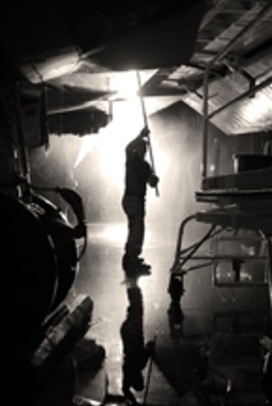 U.S. Navy Petty Officer 3rd Class Sean Robertson washes the underside a P-3 Orion aircraft wing on the flight line at Ali Air Base, Iraq, on Sept. 3, 2009.  Robertson is assigned to Combined Task Group 57.18.  