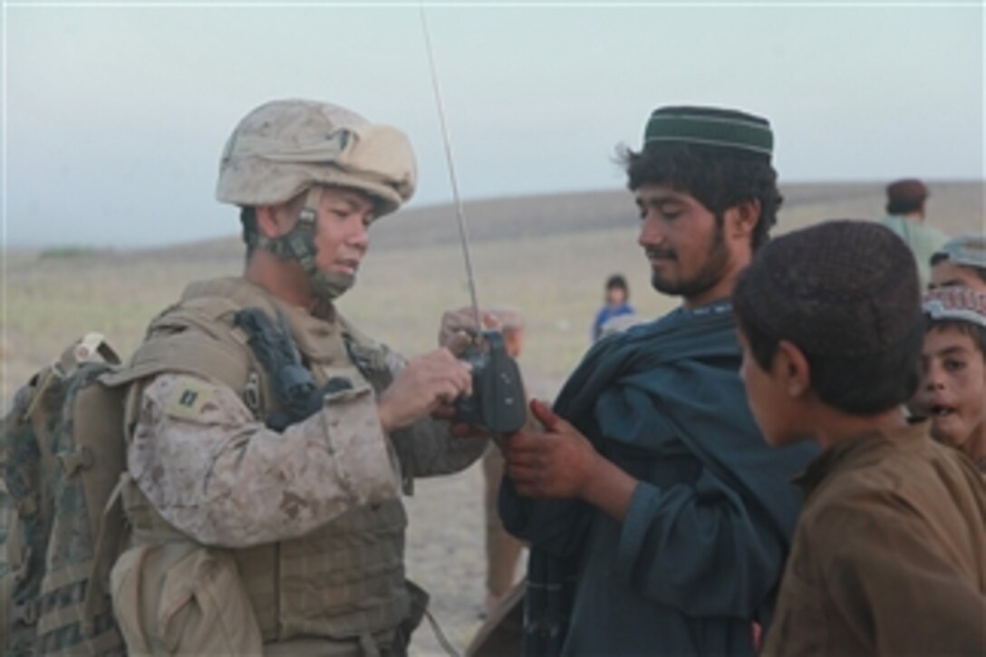 U.S. Navy Lt. Manuel Querido shows an Afghan man how to use a rechargeable radio during a medical civic action mission in the Helmand province of Afghanistan on Sept. 1, 2009.  Querido is a chaplain attached to Headquarters Battery, 3rd Battalion, 11th Marine Regiment.  The 3rd Battalion, 11th Marine Regiment is deployed with Regimental Combat Team 3 to conduct counterinsurgency operations in partnership with Afghan National Security Forces in southern Afghanistan.  