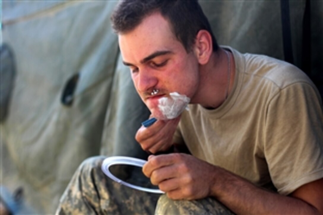 U.S. Army Spc. Kevin Anderson shaves outside his tent on Combat Outpost Tangi in Wardak province, Afghanistan, Sept. 2, 2009. Anderson is a mortar operator assigned to the 10th Mountain Division‘s Company A, 2nd Battalion, 87th Infantry Regiment, 3rd Brigade Combat Team.
