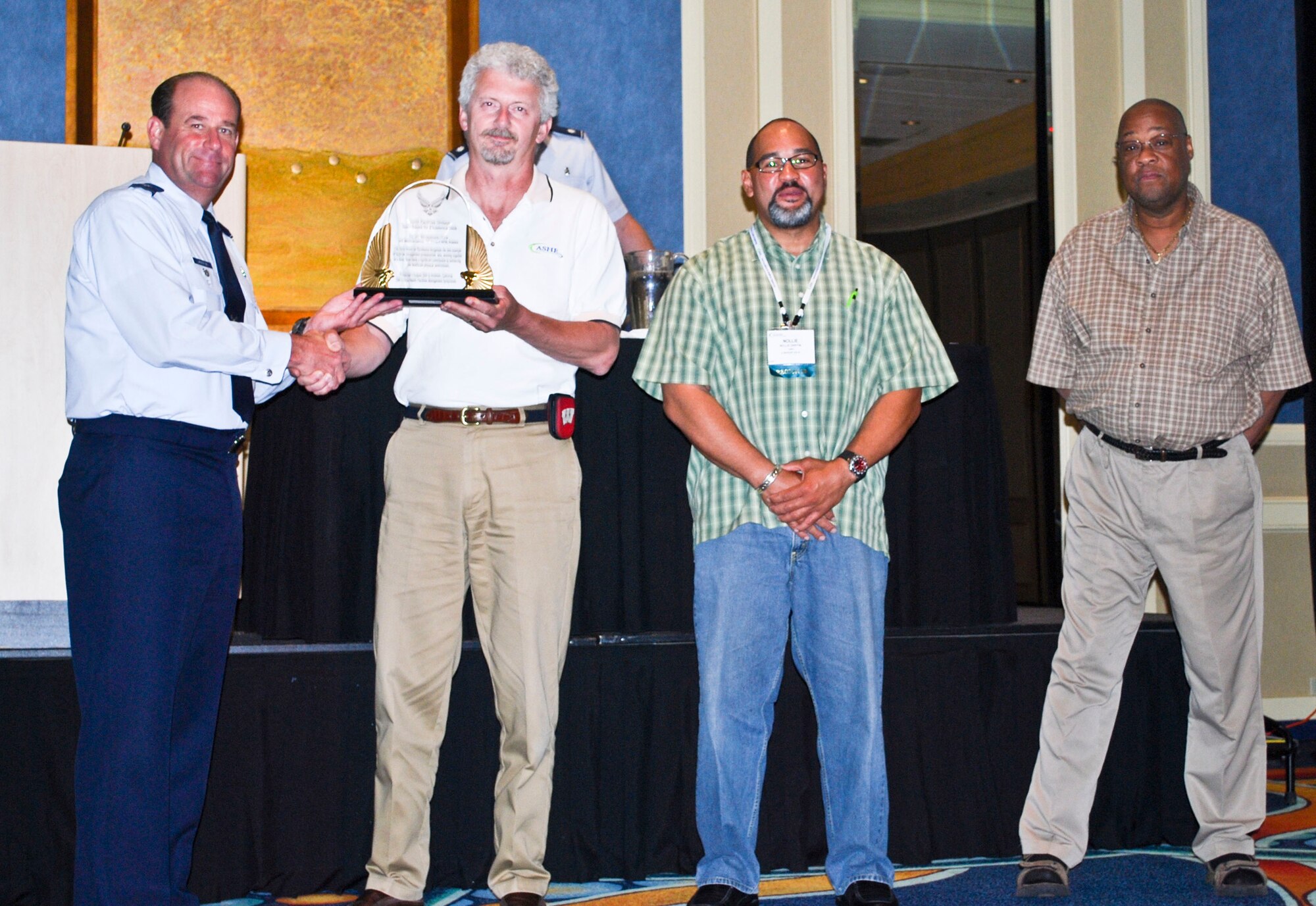 ANAHEIM, Calif. -- Col. Rex Langston, Health Facilities Division chief, presents the 2009 Air Force Facilities Team of the Year award to (from left to right) Jeff Liddle, 3rd Medical Group hospital engineer, Nollie Griffin, 3rd MDG quality assurance evaluator for maintenance contract, and Rich Vaughan, 3rd MDG housekeeping officer. The 3rd MDG?s facility management team received the award Aug. 5 during the Air Forces Facility Management Symposium in Anaheim, Calif. (Courtesy photo)