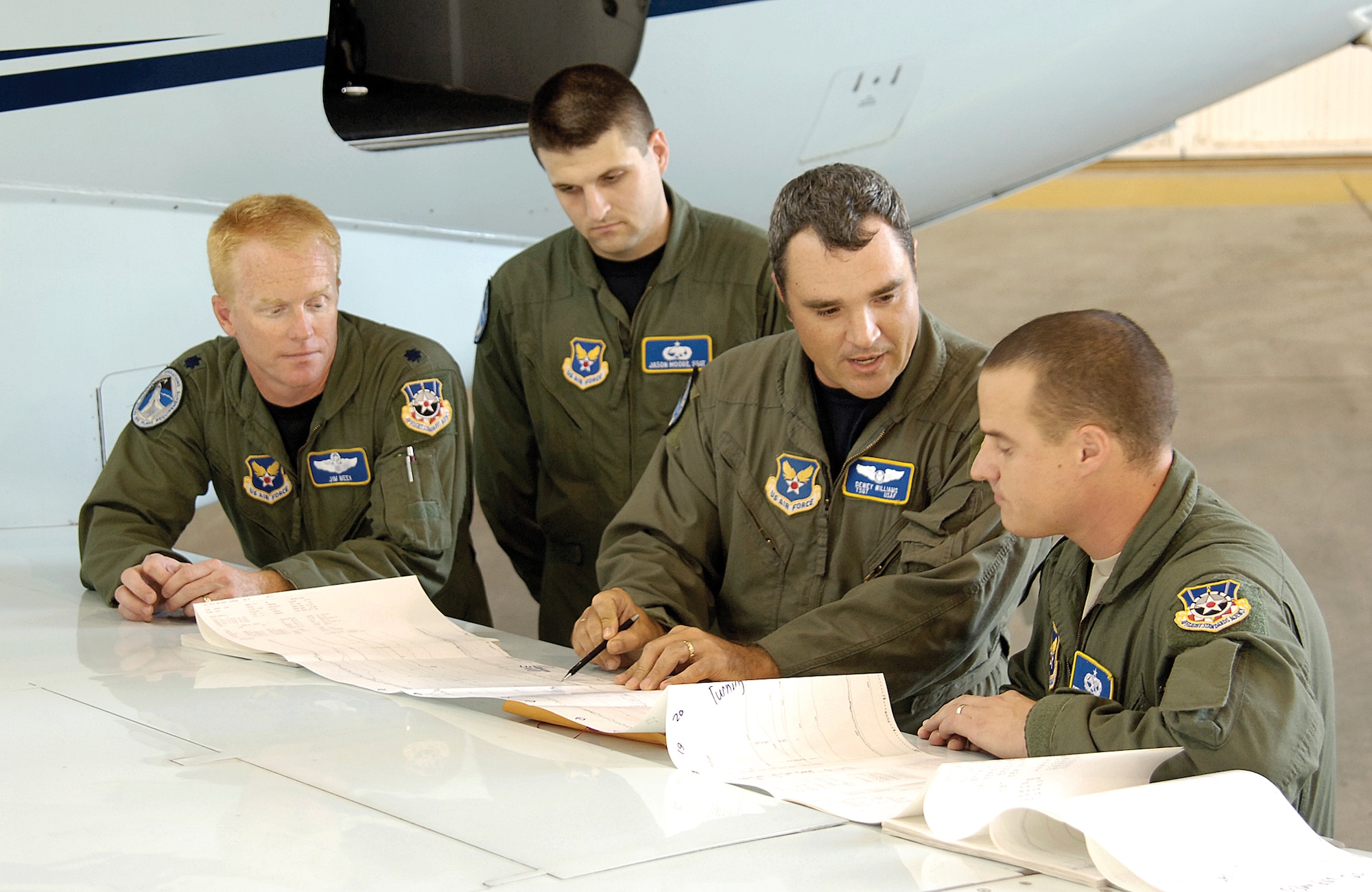 Stationed at the Mike Monroney Aeronautical Center in Oklahoma City, Air Force Flight Standards Agency aircrews fly approaches all over the world to certify that runways and equipment are safe and working properly. Reviewing information spread out on the wing of their specially equipped Challenger aircraft are (from left) Lt. Col. Jim Meek, flight inspection pilot; Staff Sgt. Jason Moore, mission specialist trainee; Tech. Sgt. Dewey Williams, mission specialist instructor; and Tech. Sgt. Peter Nichiporuk, mission specialist trainee. (U.S. Air Force photo/Margo Wright)