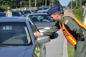 Col. John Wood shakes hands with Brian Daly at the Dorchester Road gate during the safety send off prior to the Labor Day weekend here Sept. 3. The safety send off was held as a reminder of the importance of safety during the holiday weekend. Colonel Wood is the 437th Airlift Wing commander. (U.S. Air Force photo/James Bowman)