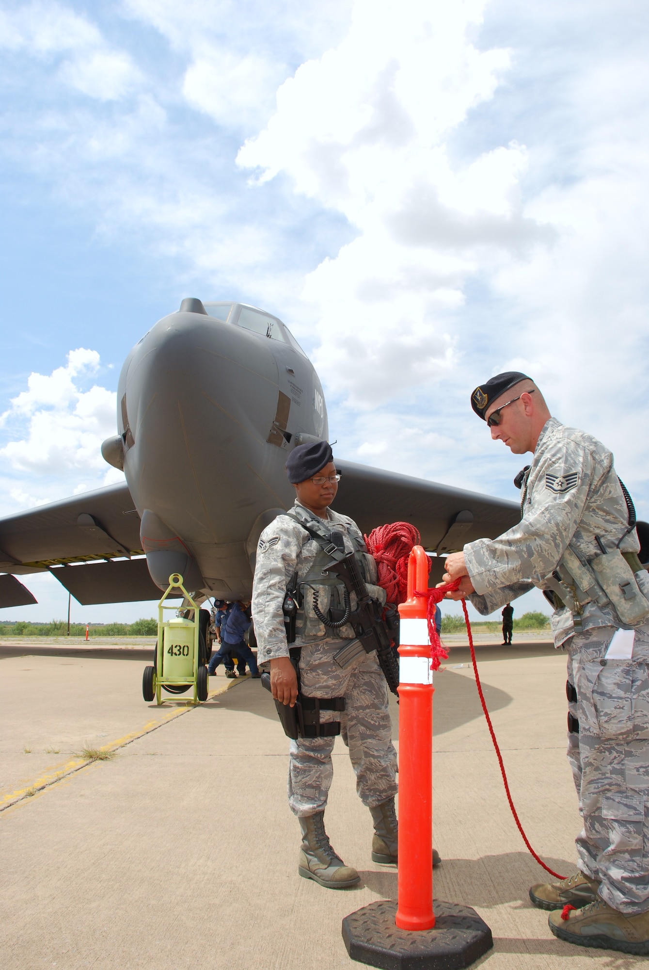 Staff Sgt. Robert Ragland, right, and Senior Airman Alexis Williams of the 82nd Security Forces Squadron set up a perimeter Sept. 9 around a B-52H Stratofortress after it landed to become a new ground instructional trainer for the 82nd Training Wing. The B-52H, was part of the first strike force to respond to the events of Sept. 11, 2001. The aircraft has nose art in memory of the event and those who lost their lives. (U.S. Air Force photo/John Ingle)