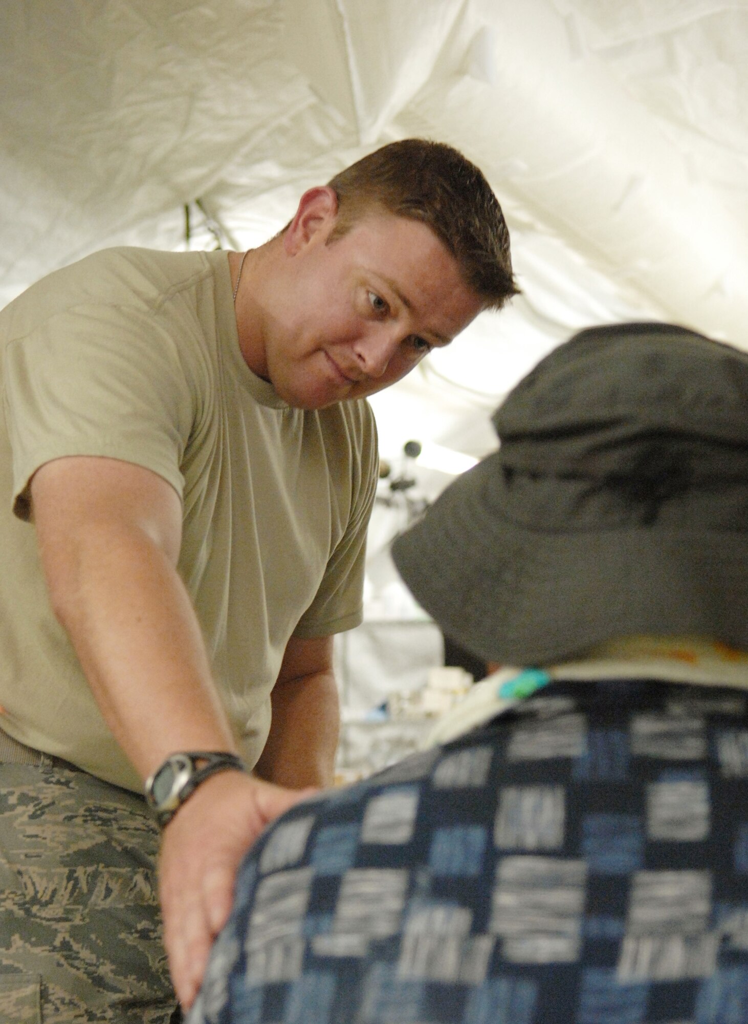 Capt. (Dr.) Christopher Lindshield speaks to a patient during the humanitarian assistance rapid response team validation exercise Sept. 4, 2009, on Chuuk, in the Federated States of Micronesia.  The team is the Air Force's new expeditionary medical capability designed to deploy within 24-hours of notice during disaster relief operations. The team provides basic medical care and public health assistance to 350 to 500 patients per day and is based at Andersen Air Force Base, Guam. Doctor Lindshield is from the 374th Medical Group at Yokota Air Base, Japan. (U.S. Air Force photo/Capt. Andrew Hoskinson)