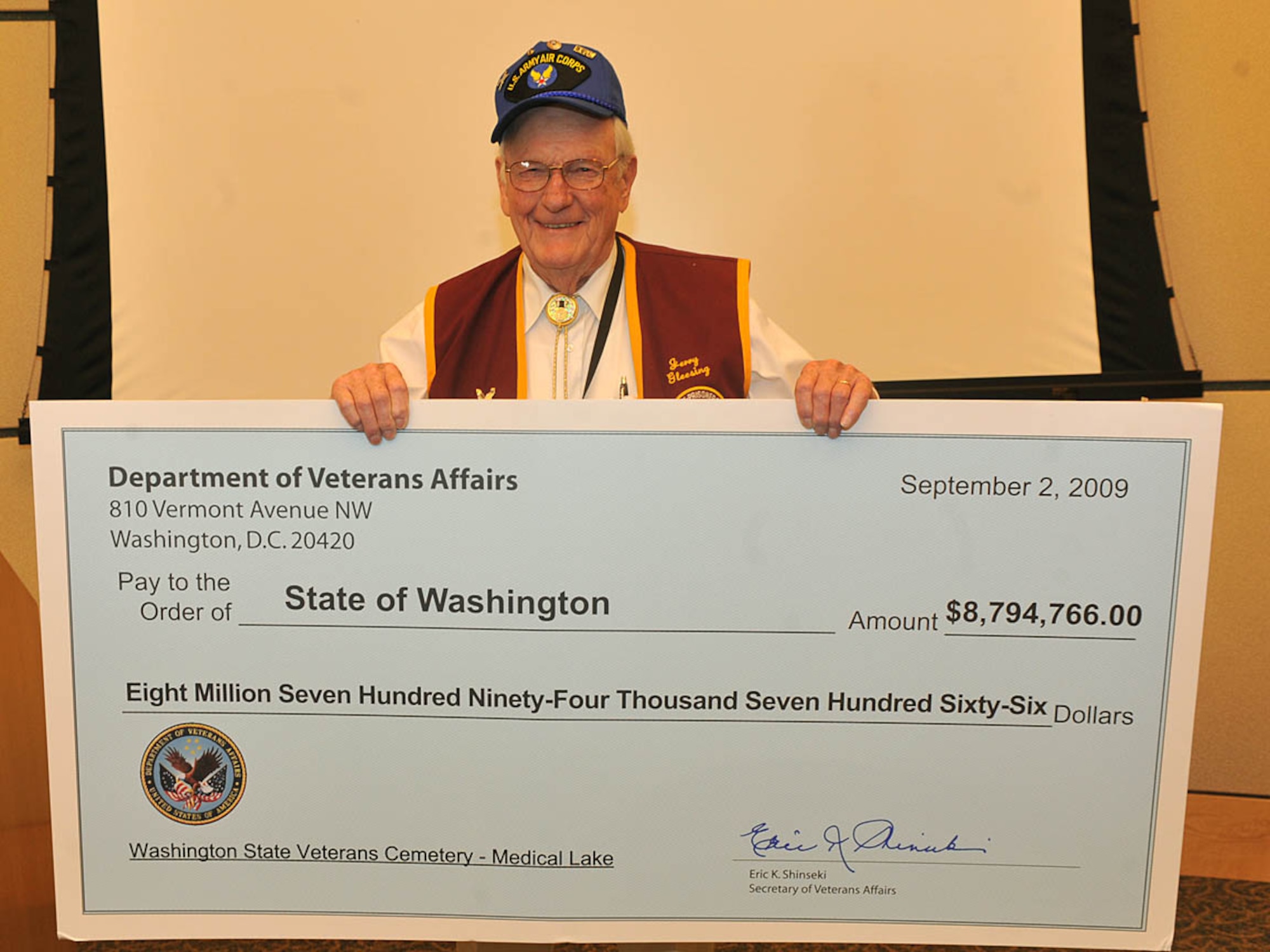 Jerry Glessing, American EX- Prisoners of War chapter commander, poses with the $ 8,794,766 check during the State Veteran’s Cemetery ceremony Sept. 2. The event took place at the Spokane Regional Business Center. The grant was presented for a new cemetery located in Medical Lake, WA. The cemetery will serve approximately 140,000 Washington Veterans and their families. (U.S. Air Force photo / Staff Sgt. JT May III)
