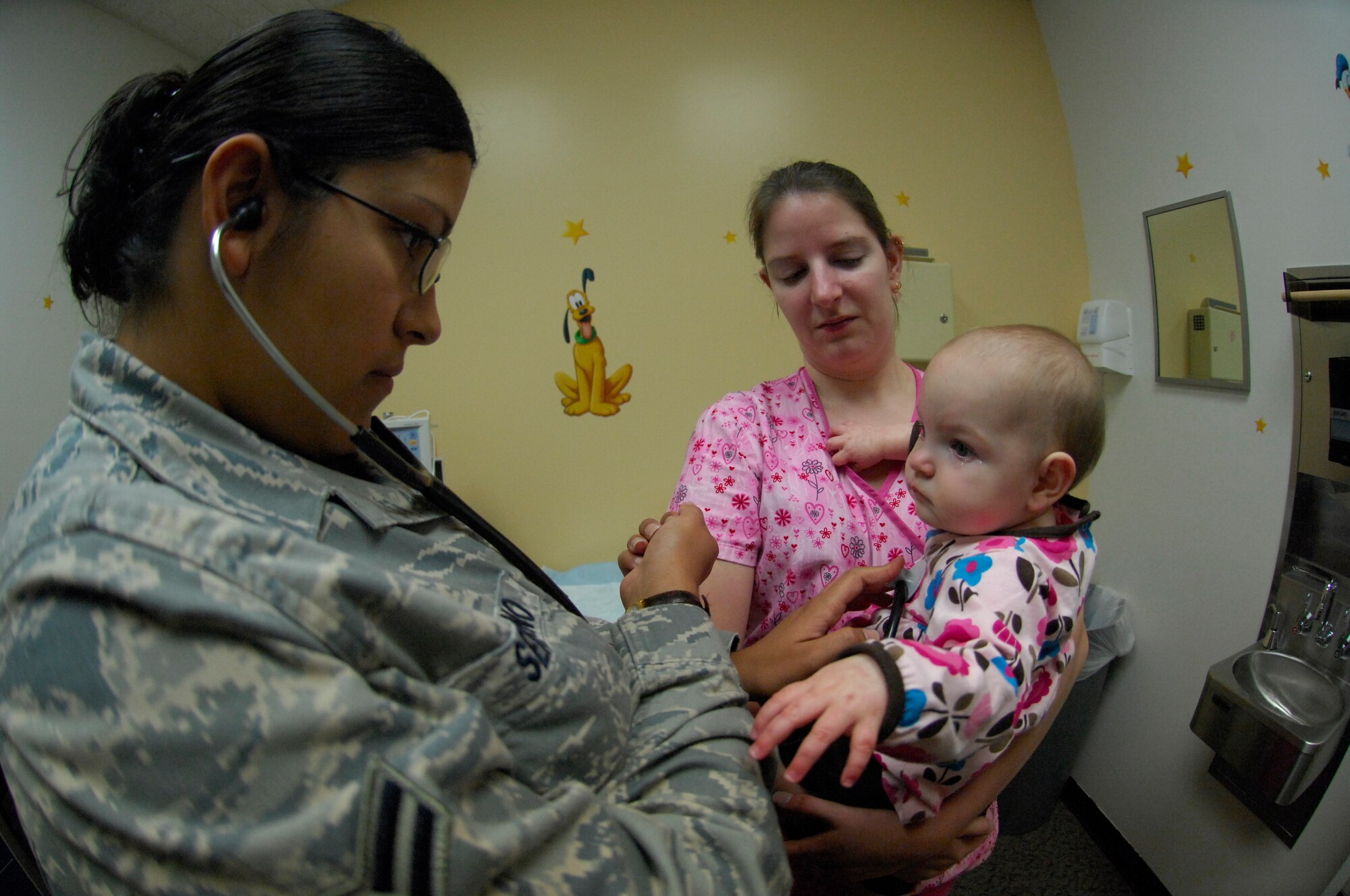MINOT AIR FORCE BASE, N.D.-- Airman 1st Class Jessica Serrano, 5th Medical Group medical technician, examines the heart rate of 4 month old Addy Toepper here, Sep. 7. The 5th Medical Group offers outpatient services including family practice, dental, pediatrics, internal medicine, aerospace medicine, physical therapy, optometry and women’s health care. (U.S. Air Force photo by Airman 1st Class Jesse Lopez)