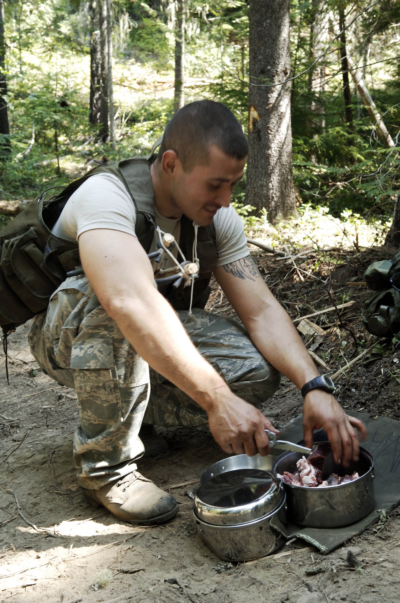 Staff Sgt. Bruno Lima, Survival, Evasion, Resistance and Escape candidate, prepares meat for cooking during the Familiarization phase of SERE training. (U.S. Air Force photo/Senior Airman Emerald Ralston)