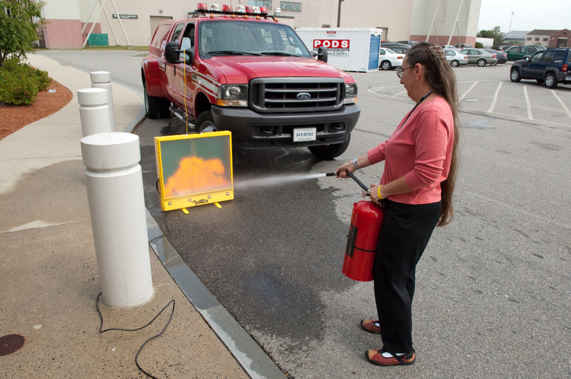 HANSCOM AIR FORCE BASE, Mass. –JoAnn Grant, tries her hand at extinguishing a fire at one of the Safety Day displays set up at the Hanscom Commissary on Sept. 3. The 66th Air Base Wing Safety Office organized the Safety Day that included participation from the Fire Department, 66th Security Forces, Bioenvironmental and the AAFES Safety Office.  (U.S. Air Force photo by Rick Berry) 