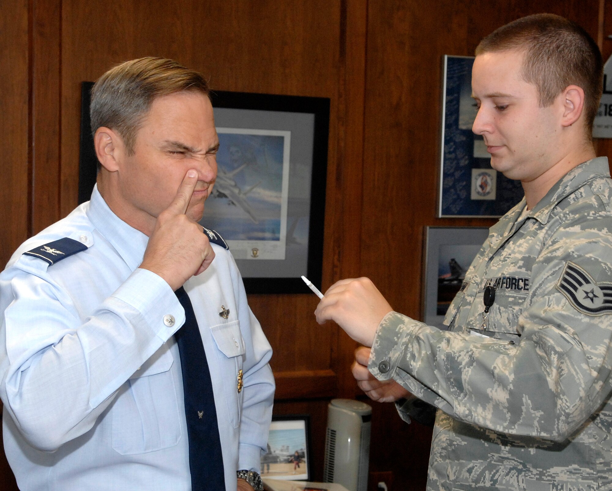 “A minty fresh taste,” says Col. Chris Nowland, left, after receiving the FluMist influenza vaccination Sept. 4, at Vance AFB, Okla. Colonel Nowland, the 71st Flying Training Wing commander, received the 2009 seasonal flu vaccination by nasal mist from Staff Sgt. Travis Sullivan, assistant NCO in charge of the 71st Medical Group’s immunization clinic. Flu vaccinations begin for Vance military members Sept. 18. (U.S. Air Force photo/ Terry Wasson)