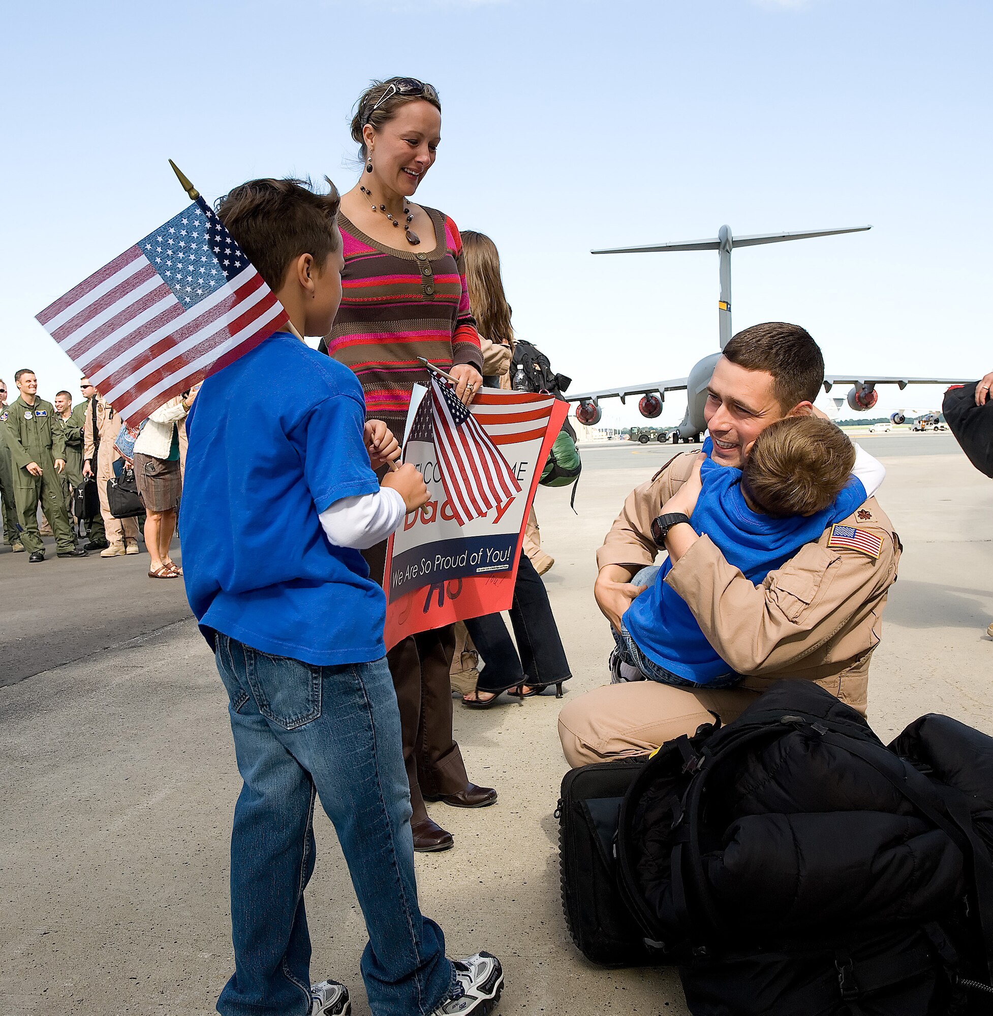 Maj. Dan Cooley, 3rd Airlift Squadron assistant operations officer and aircraft commander, hugs his son Gavin, 5, after returning to Dover Air Force Base Sept. 2, while his wife Therese, and oldest son Ty, 7, look on. Major Cooley and the nearly 120 members of the 3rd AS deployed to Southwest Asia in April as the 816th Expeditionary  Airlift Squadron to provide combat airlift and airdrop, aeromedical evacuations, humanitarian relief and distinguished visitor movement in the U.S. Central Command area of responsibility. (U.S. Air Force photo/Jason Minto)