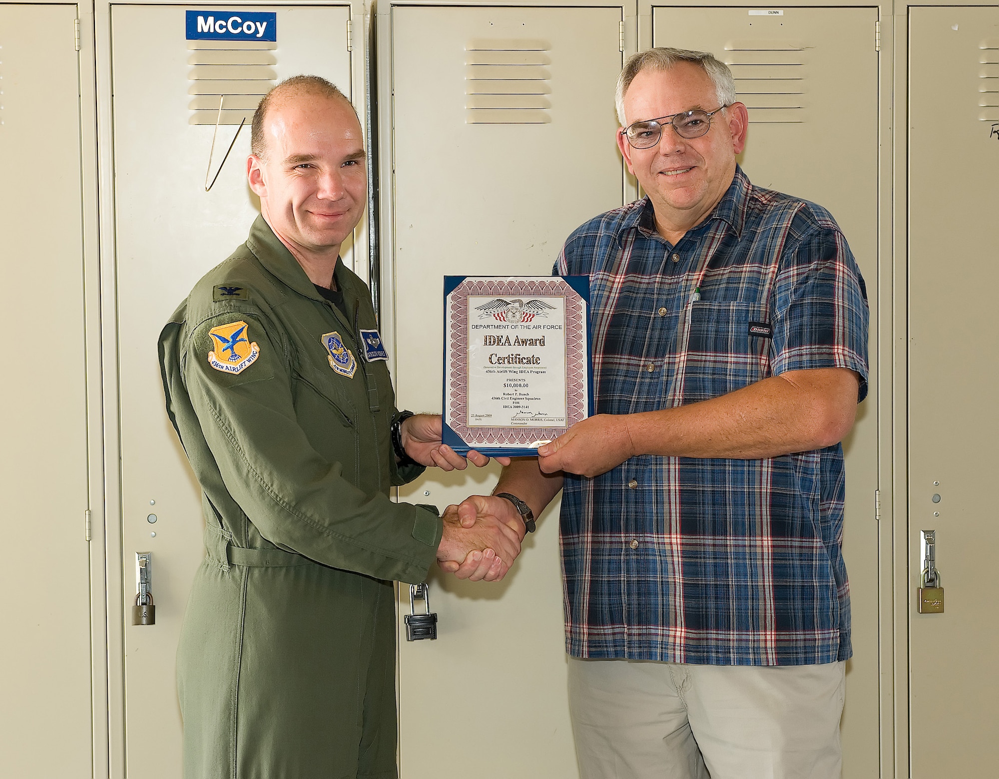 (Right) Bob Bunch, 436th Civil Engineering Squadron maintenance mechanic, receives a certificate for his IDEA award from Col. Manson Morris, 436th Airlift Wing commander, Sept. 2. Mr. Bunch suggested installing power-saving capacitors on all facilities of Dover Air Force Base, Del. The capacitors are estimated to reduce Dover's power usage by 15 million kilowatt hours a year resulting in a savings of $1.5 million a year. (U.S. Air Force photo/Jason Minto)