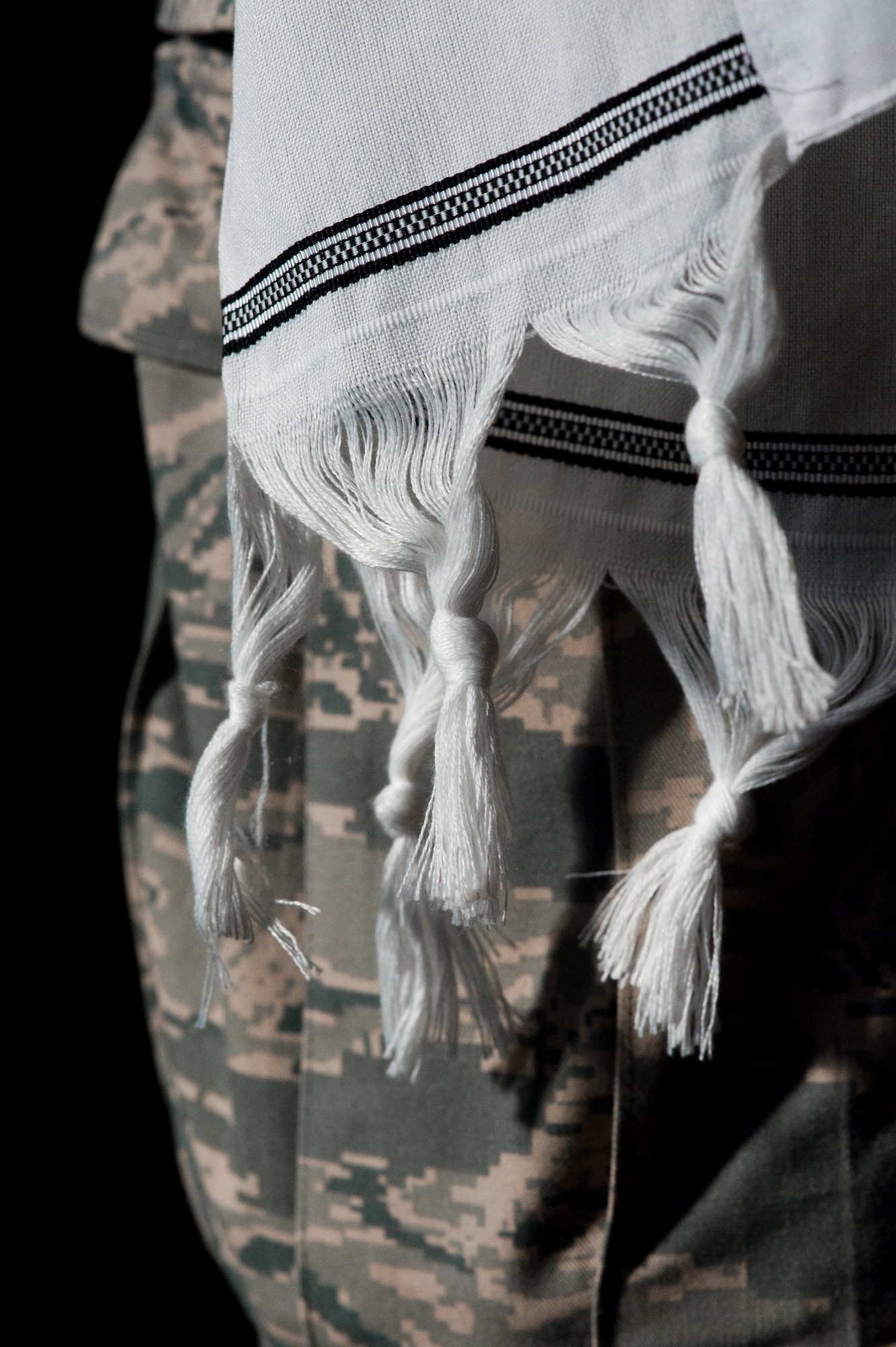 The tzit tzit, knotted fringe at the end of the prayer shawl worn by U.S. Air Force Rabbi, Chaplain, Captain Sarah D. Schechter during the evening le'il shabbat service on Friday, Sept. 4, 2009 symbolize the 613 commandments in the Torah.  At Lackland Air Force Base's Airmen Memorial Chapel more than 25 basic military trainees and other attendees participated in a religious education class, then Ma'ariv prayer service for the setting of the sun, followed by a meal provided by lay leaders supporting the service. Because of training schedules some ceremonies and events are earlier than traditionally held. By order of commanders, those who want to attend any or all religious services of their choosing are given full permission and opportunity to do so.  Chaplain, Captain Schechter is an Operation Iraqi Freedom veteran and considers her deployment there to be one of the highlights of her career. Schechter is the first woman rabbi in the U.S. Air Force. (U.S. Air Force photo/Lance Cheung)

