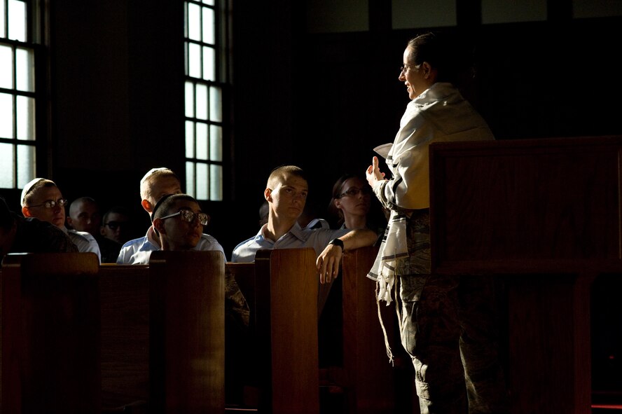 U.S. Air Force Rabbi, Chaplain, Captain Sarah D. Schechter (standing and wearing a tallit, prayer shawl) leads the evening le'il shabbat service using notes and a special edition siddur: "For Jewish personnel in the Armed Forces of the United States,"  on Friday, Sept. 4, 2009 at Lackland Air Force Base's Airmen Memorial Chapel. The more than 25 basic military trainees and other attendees participated in a religious education class, then Ma'ariv prayer service for the setting of the sun, followed by a meal provided by lay leaders supporting the service. Because of training schedules some ceremonies and events are earlier than traditionally held. By order of commanders, those who want to attend any or all religious services of their choosing are given full permission and opportunity to do so.  Chaplain, Captain Schechter is an Operation Iraqi Freedom veteran and considers her deployment there to be one of the highlights of her career. Schechter is the first woman rabbi in the U.S. Air Force. (U.S. Air Force photo/Lance Cheung)
