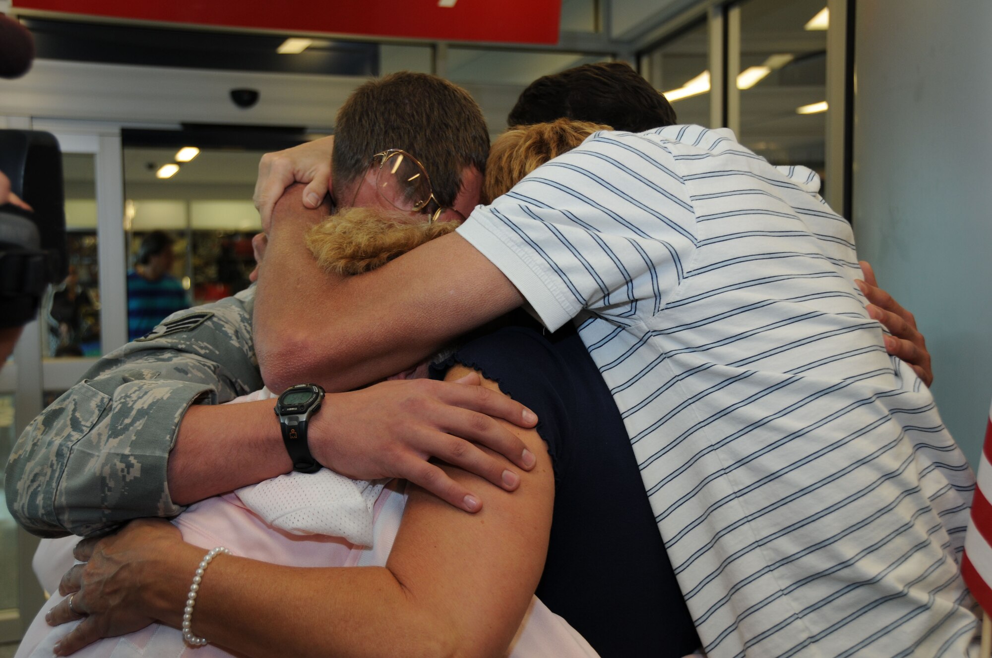 Senior Airman Justin Goerss is swarmed by loved ones upon his arrival home after a six month deployment to Sather Air Base Iraq. (U.S. Air Force photo/Staf. Sgt. Peter Dean)