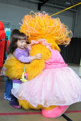 RAF MILDENHALL, England -- Leila Didomenico, 2, gives a hug to Zoe, a Muppet on the Sesame Workshop/United Service Organization's free traveling tour, at the conclusion of their first show in the Northside Fitness Center here Sept. 8. RAF Mildenhall was the first stop for the international show. About 1,000 people attended the shows titled "Talk, Listen, Connect" geared to young children experiencing the effects of deployment, multiple deployments or a parent returning home changed due to a combat-related injury. (U.S. Air Force photo/Senior Airman Thomas Trower) 