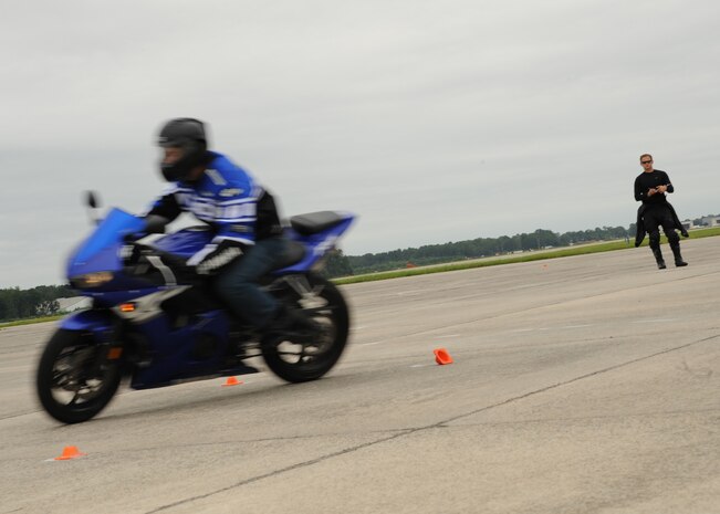 Tech. Sgt. Nelson Irizarry watches Senior Airman Kale Pascua perform a turn during the Sport Bike Course on Charleston AFB's flightline Sept. 2. The motorcycle course allows riders to become more competent with their bike in an environment significantly safer than public roads. Sergeant Irizarry is with the 315th Aircraft Maintenance Squadron and Airman Pascua is with the 560th Red Horse Squadron. (U.S. Air Force photo/Senior Airman Katie Gieratz)(RELEASED)  