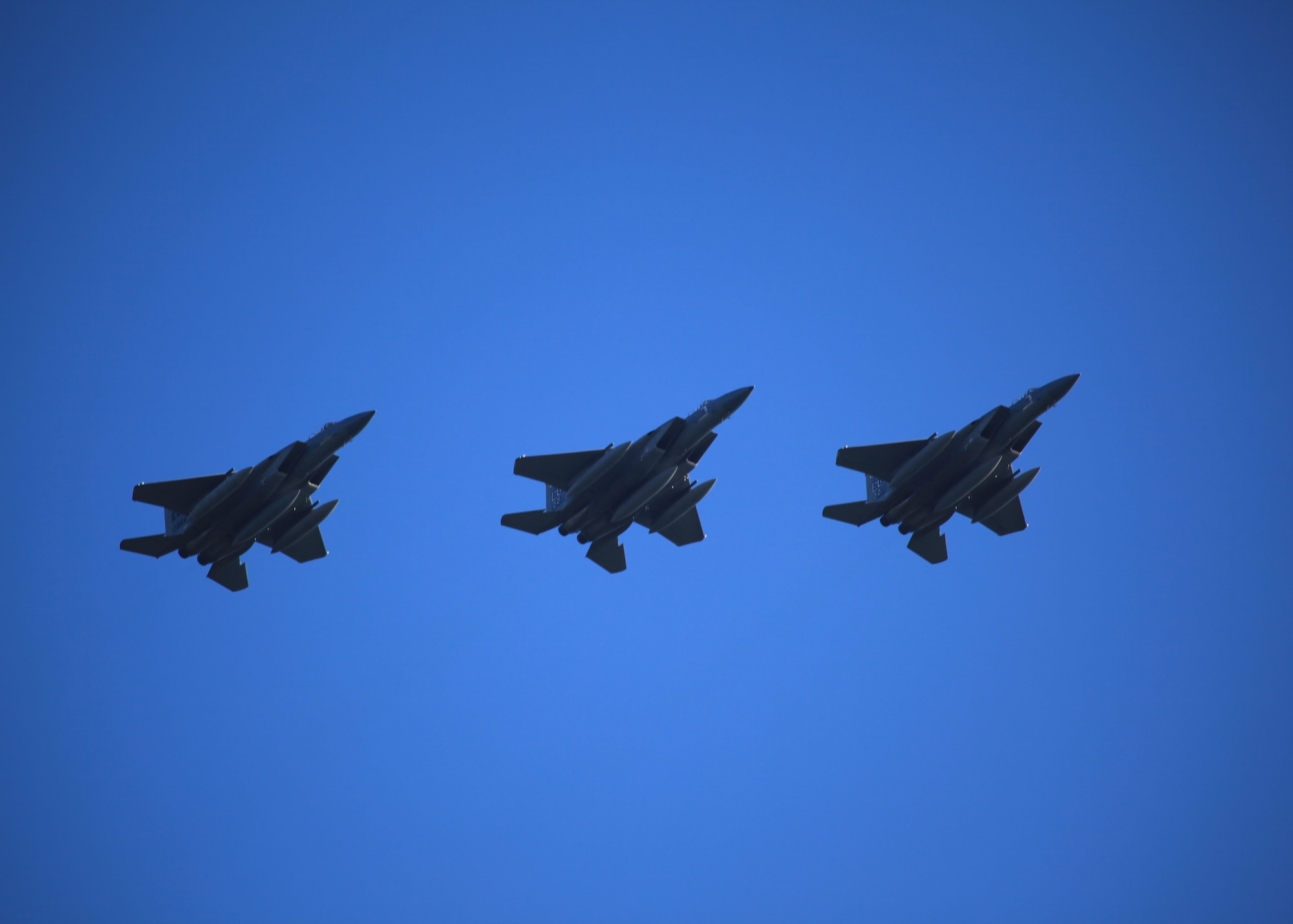 An F-15 three-ship flies over the 33rd Fighter Wing's now empty ramp, marking the end of their 30-year legacy of Eagle driving here Sept. 8. Aircraft will not begin to fill up the ramp until the Joint Strike Fighter arrives here next year, following the Oct. 1 wing transition to Air Education and Training Command. The last three Eagles left Eglin to join the standby fleet at Air Force Material Command's 309th Aerospace Maintenance and Regeneration Group in Tucson, Ariz. (U.S. Air Force photo by Tech. Sgt. Eric Jacobson) 