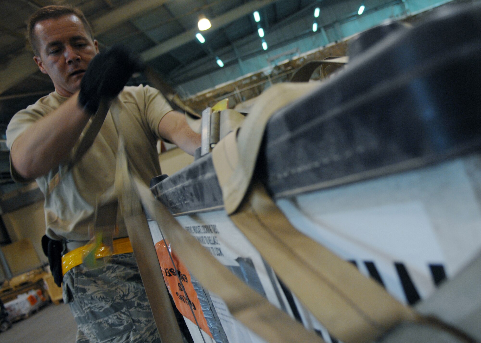 JOINT BASE BALAD, Iraq -- Tech. Sgt. Brent Parrish of the 332nd Expeditionary Logistics Readiness Squadron removes cargo netting from a pallet before moving it to the special handling section here Aug. 26. Special handling cargo consists of equipment such as ammo, rockets or any hazardous material. (U.S. Air Force photo/Senior Airman Christopher Hubenthal)