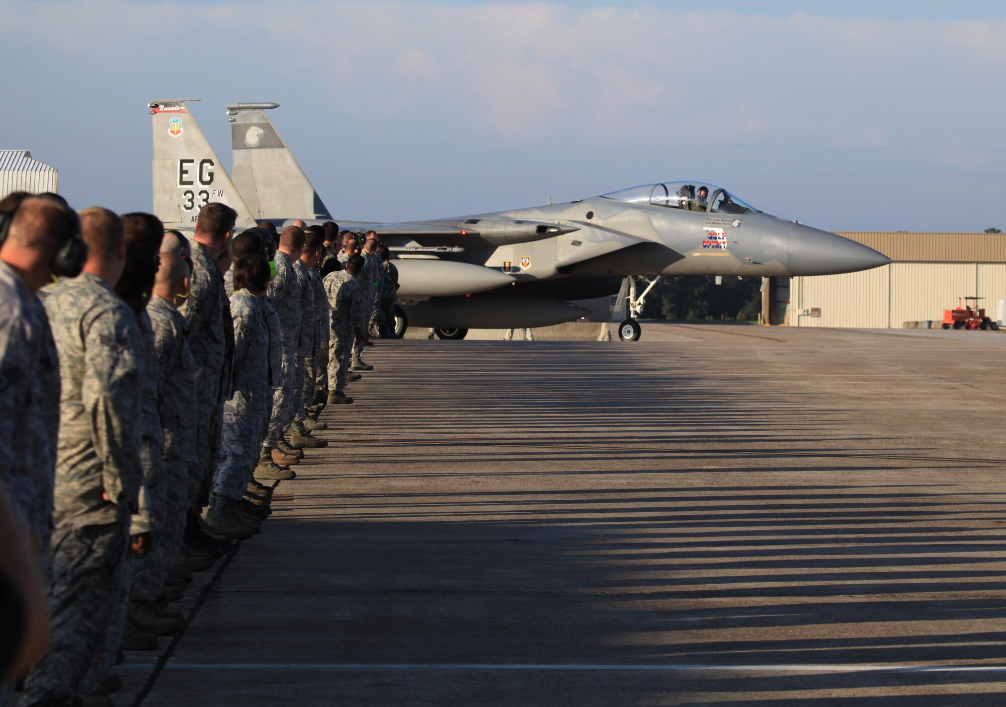 Remaining Nomads of the transitioning 33rd Fighter Wing and members of Team Eglin prepare to salute Col. Todd Harmer as he taxies his F-15 flagship toward the runway Sept. 8. It was the last mission of his command and the end of a 30 year era the 33rd FW's Eagle flying operations. The last three Eagles left Eglin to join the standby fleet at Air Force Material Command's 309th Aerospace Maintenance and Regeneration Group in Tucson, Ariz. (U.S. Air Force photo by Tech. Sgt. Eric Jacobson)