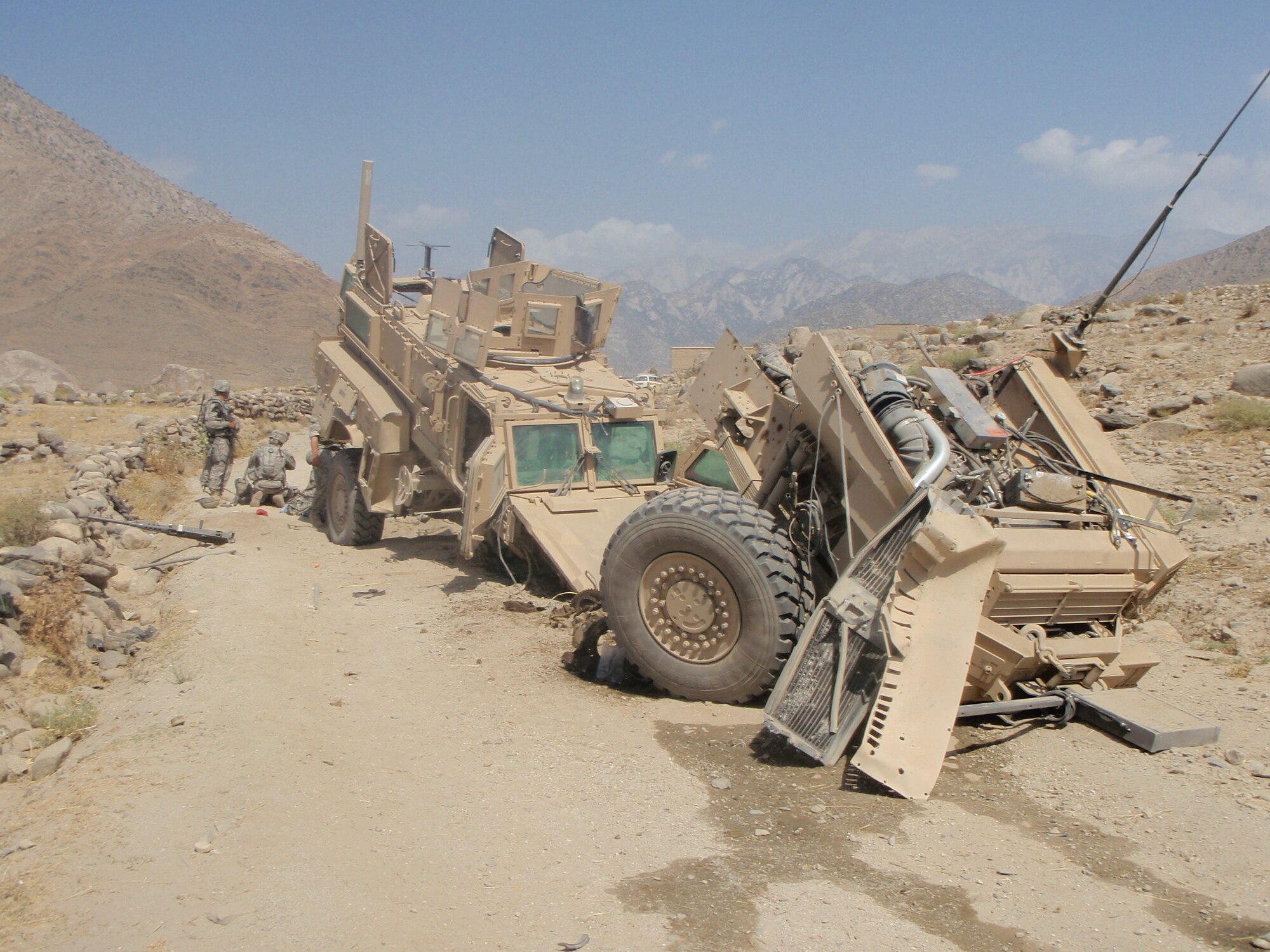 The Mine Resistant Ambush Protected vehicle lies in disarray after being struck by an improvised explosive device while returning from a humanitarian mission to give medical attention to women and children at a small Afghan village Aug. 12. Airman Dowdy was able to perform life-saving aid to injured Soldiers who were also on the convoy mission. (U.S. Air Force photo by Airman 1st Class Destiney Dowdy)